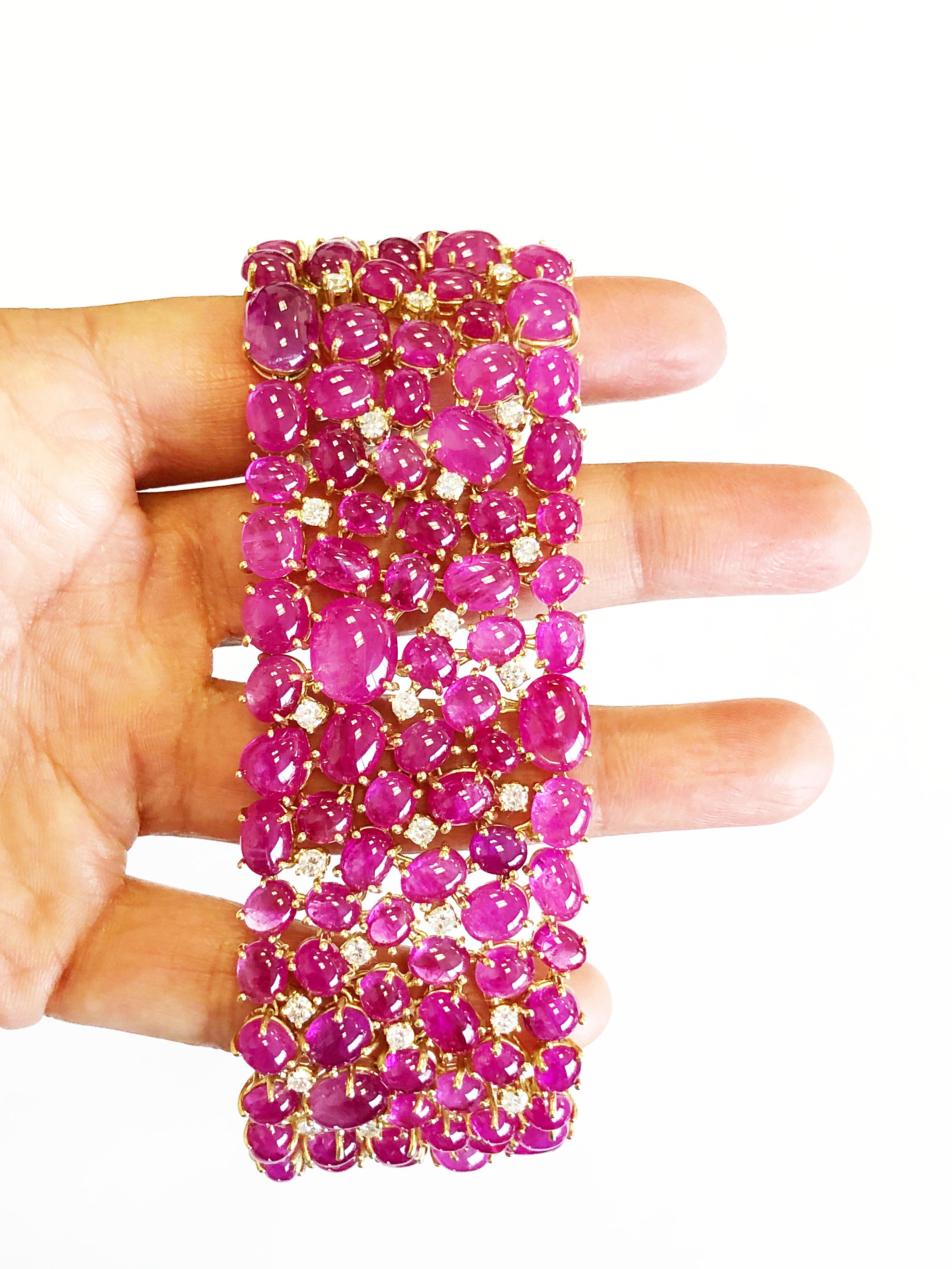 This breathtaking cluster bracelet showcases a hue of Burmese red ruby cabochons weighing 202.57 carats and 2.79 carats of white bright diamond rounds.  Handcrafted in a dainty, flexible, yet solid manner in 18k yellow gold.  Standard length of 7