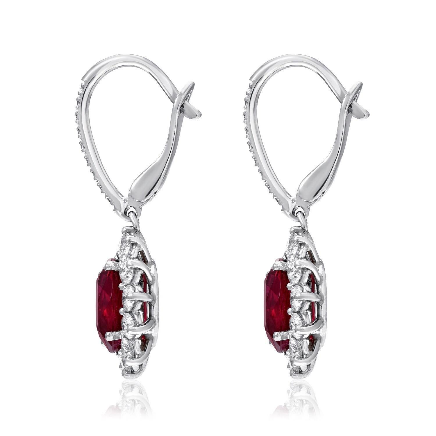 Burma Ruby earrings, exhibiting a sensational oval pair of GIA certified 3.51 carat total Rubies, adorned by a total of 1.21 carats of round brilliant diamonds, in 18K white gold with lever backs.
These lever back drop earrings are approximately 1