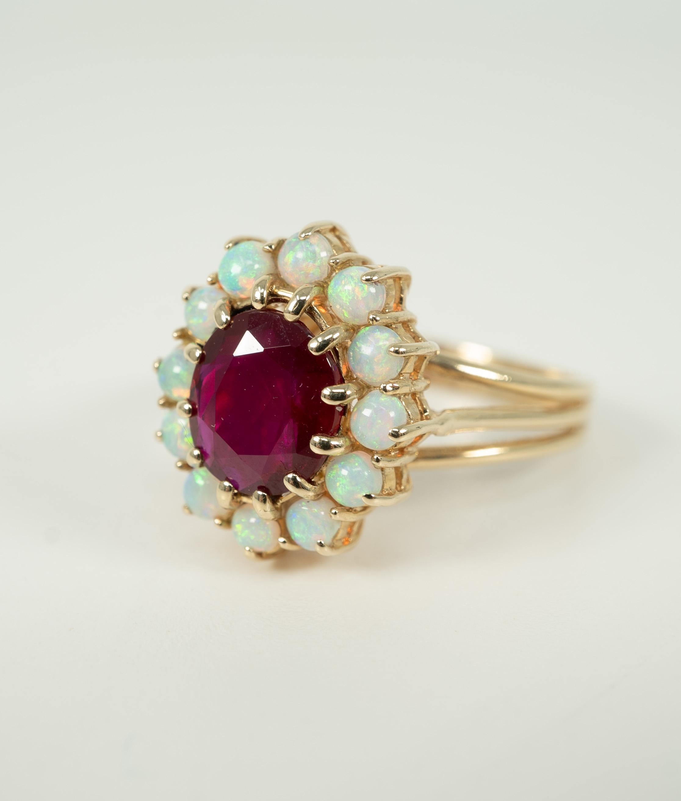 Lovely opals surround this oval-shaped 2.23 carat Burma ruby.    