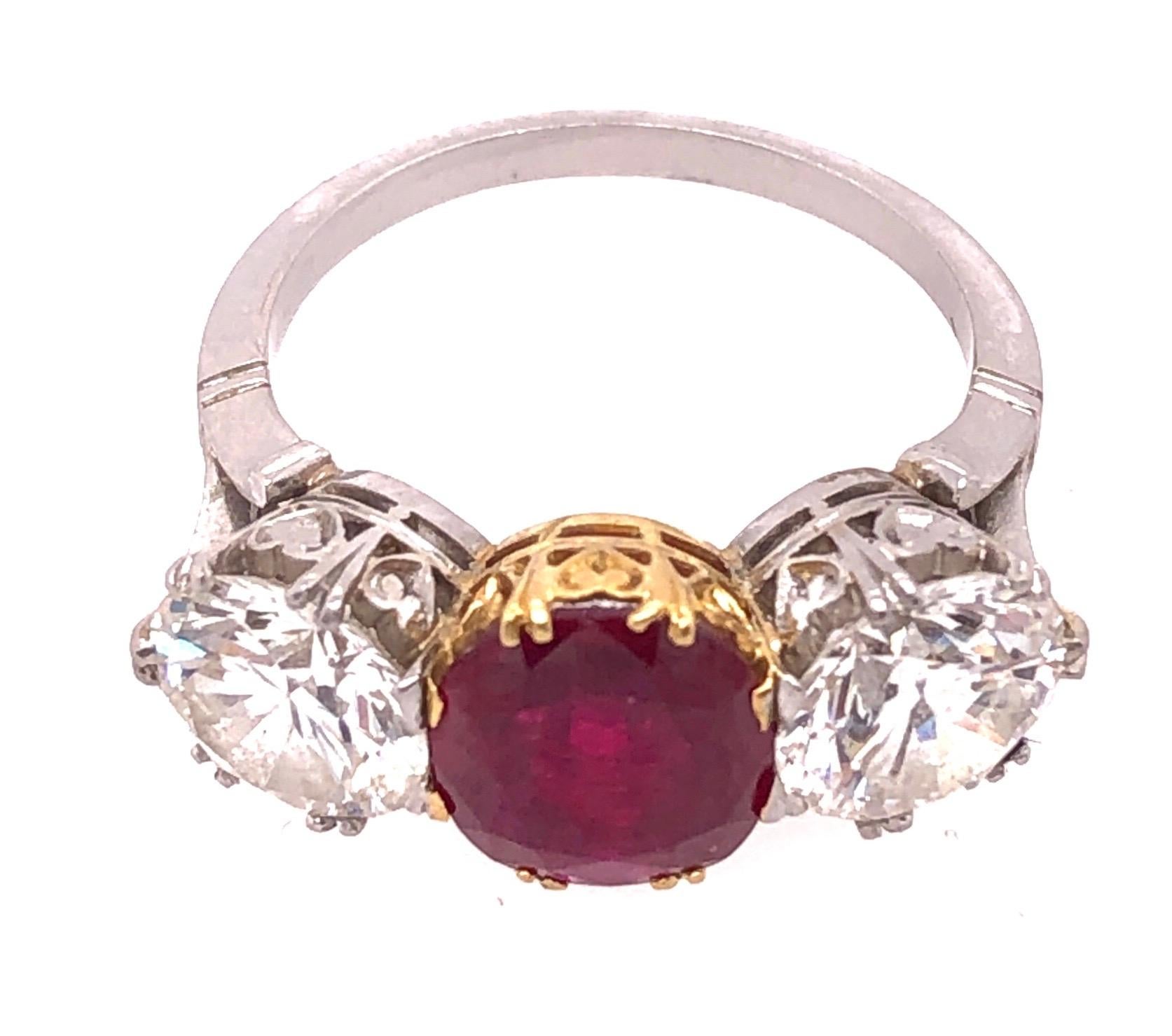 Two Tone Gold Three Stone Large Burma Myanimar Ruby Double Diamond Dinner Ring. Having a large and impressive bright ruby red center stone set in yellow gold flanked by  two diamonds set in white gold each weighing approximately 1.60 carat. The