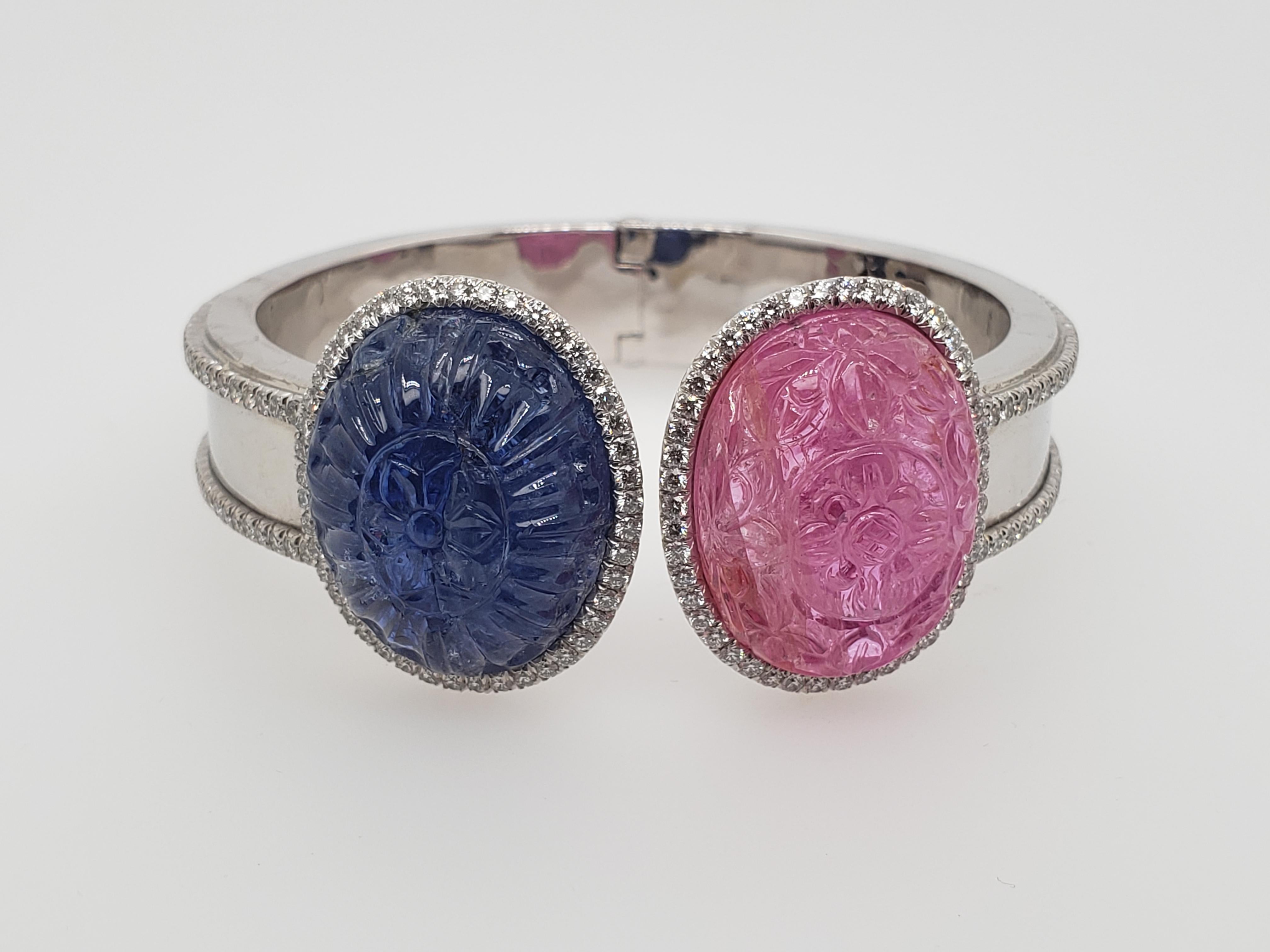 Pink & Blue Carved Cabochon Burma Sapphire & Ruby Bangle

Featuring two Oval-shaped carved with an elaborate floral pattern cabochon Pink and Blue sapphires weighing 49.81 and 46.01 carats, with AGTA Certificates Stating they are of Burma Origin,