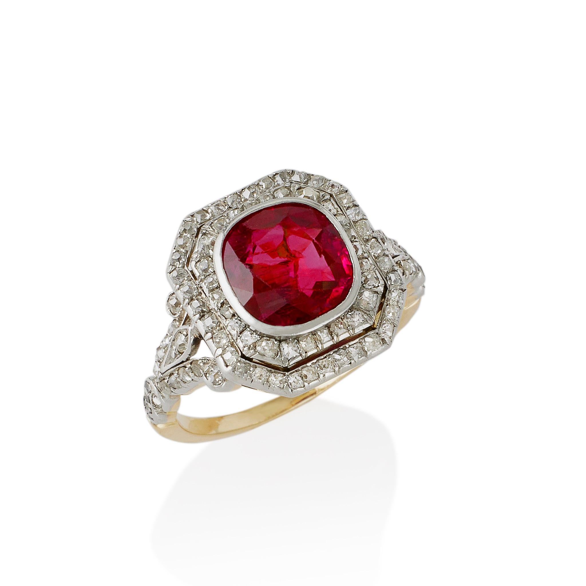 Dating from circa 1900, this ruby and diamond ring is set in platinum and 18K gold. It is bezel-set with an untreated Burma cushion-cut ruby, measuring approximately 8.05 x 7.65 x 3.95 mm, and weighing approximately 1.85 carats, framed by a stepped