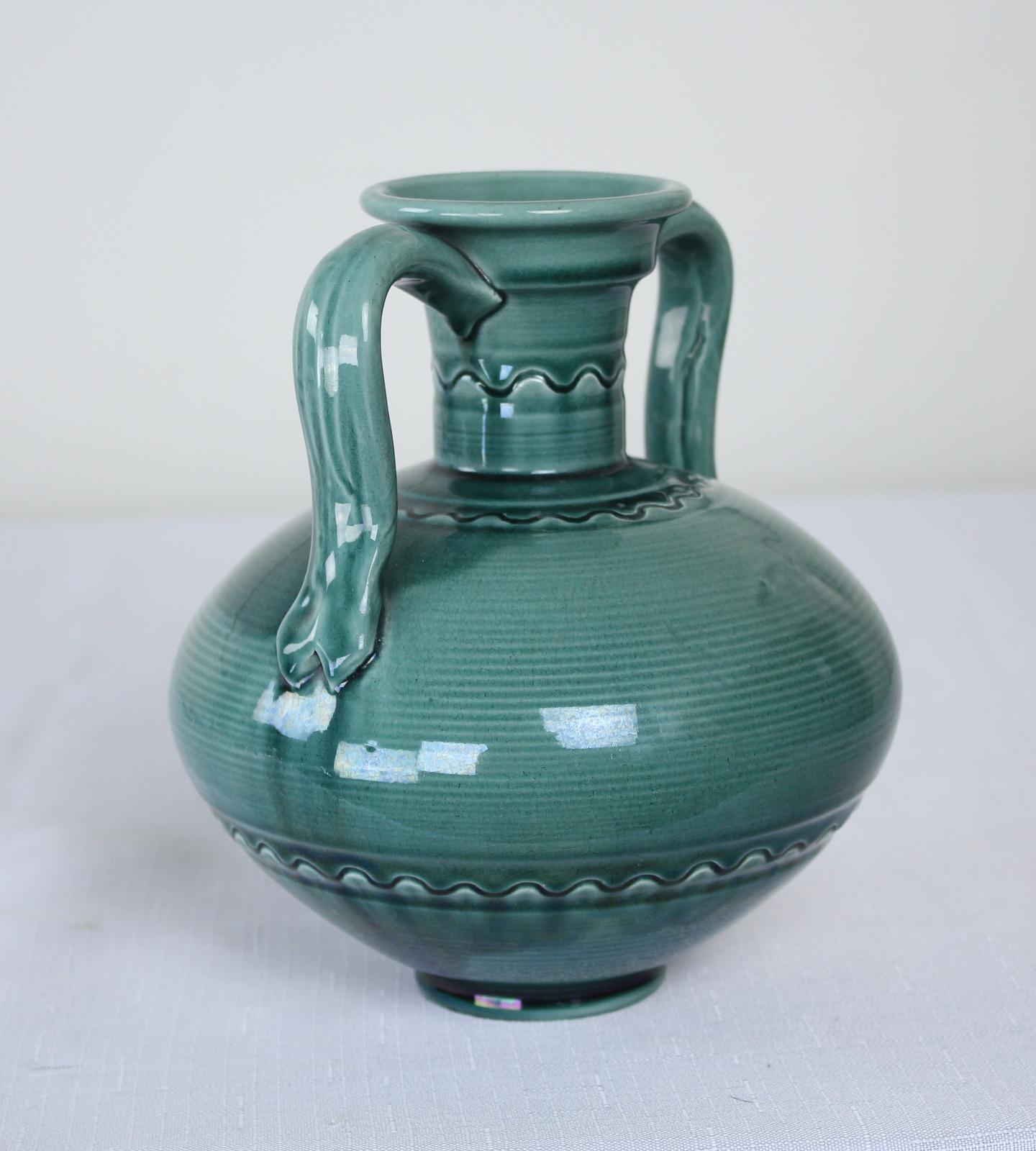 Art pottery vase by Burmantofts in the manner of Christopher Dresser. Anglo-Persian design, very popular in the period, with bulbous body and thin cylindrical neck, with a shaped handle to either side. In a striking shade of green. In good condition