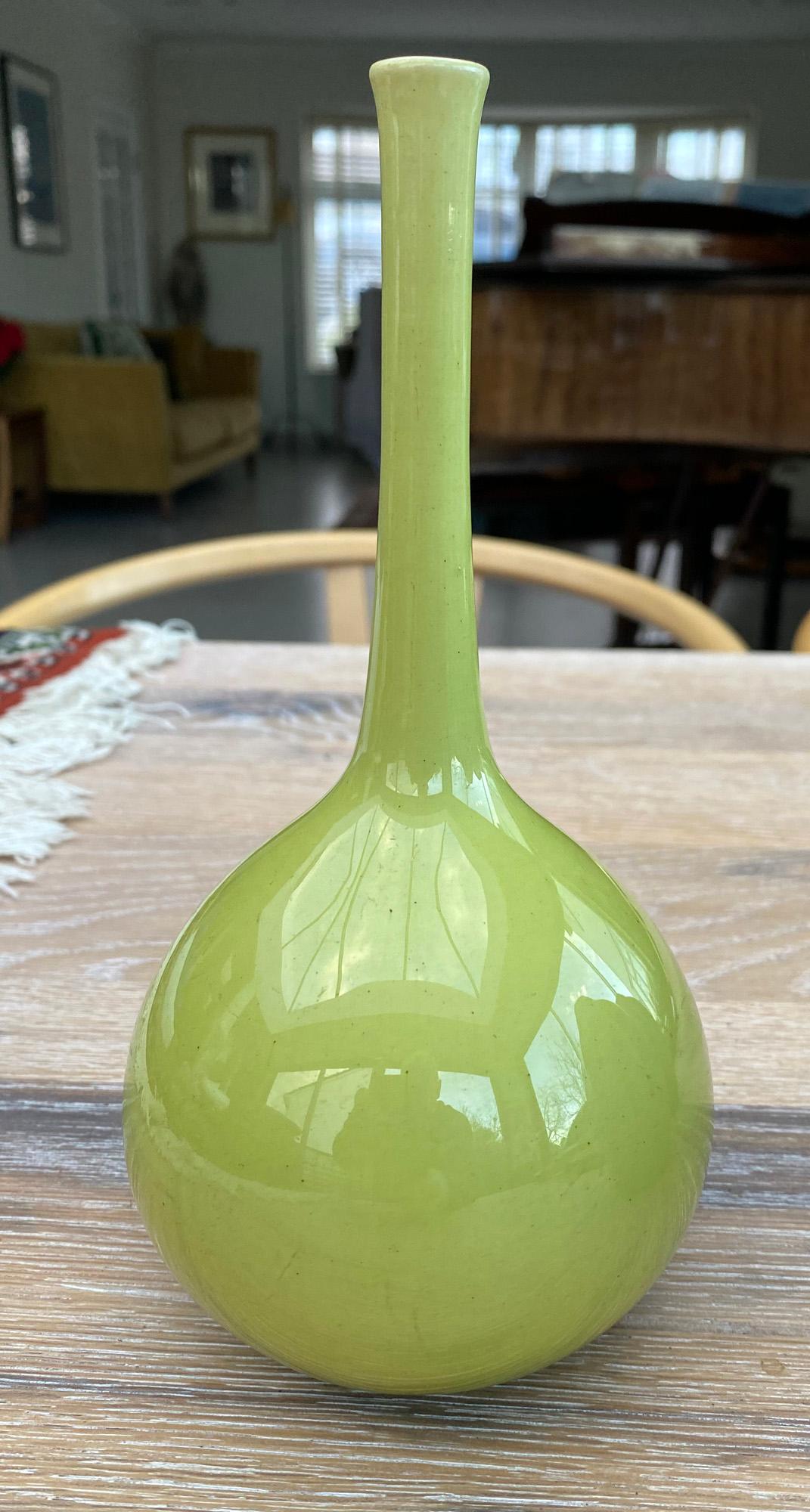 A Burmantofts art pottery green glazed bottle vase signed to base together with a Mdina glass bowl with crimped rim and signed to base.