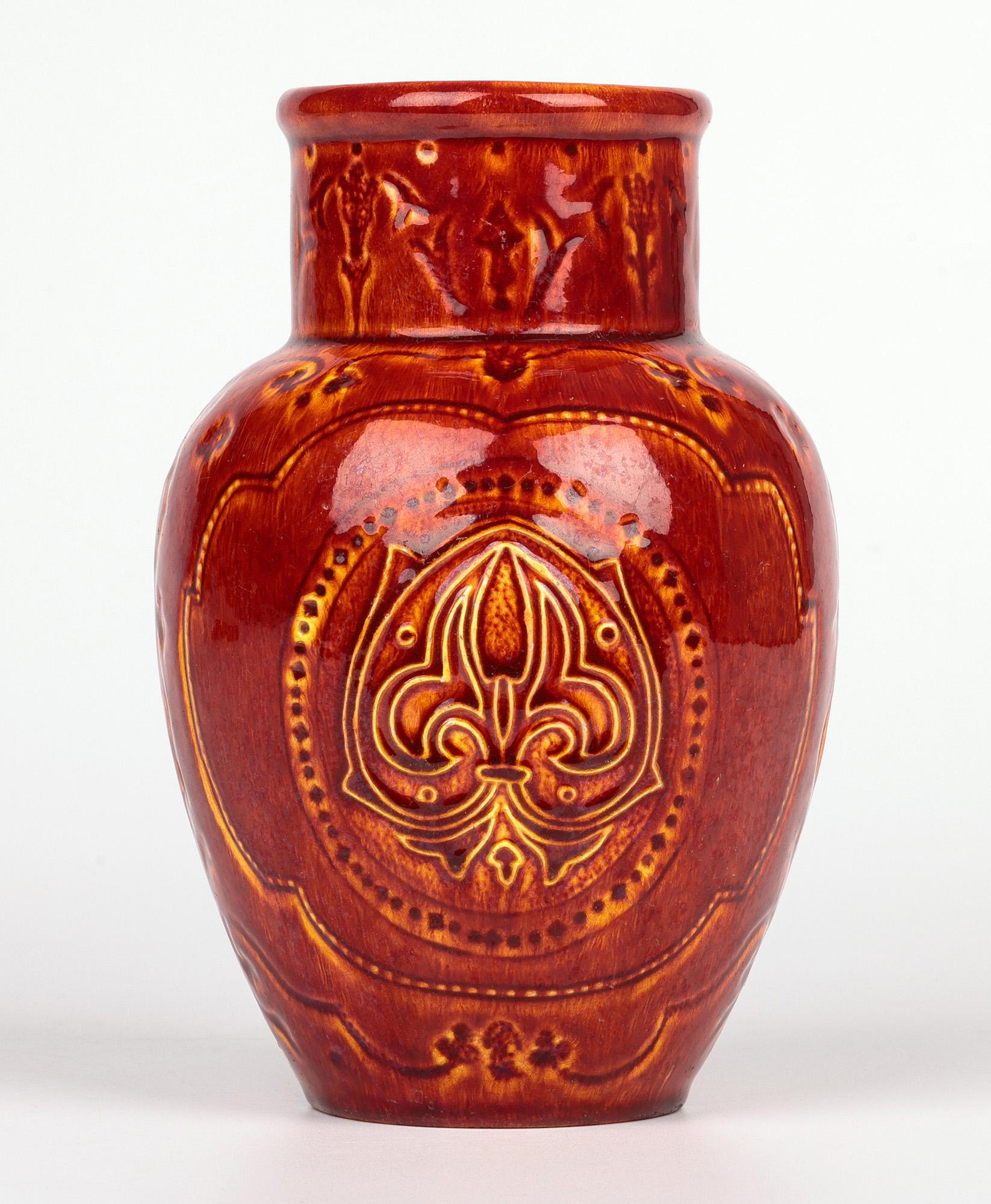 Raro jarrón de cerámica artística Burmantofts Faience con flor de lis esmaltada en rojo y amarillo en Bueno estado para la venta en Bishop's Stortford, Hertfordshire