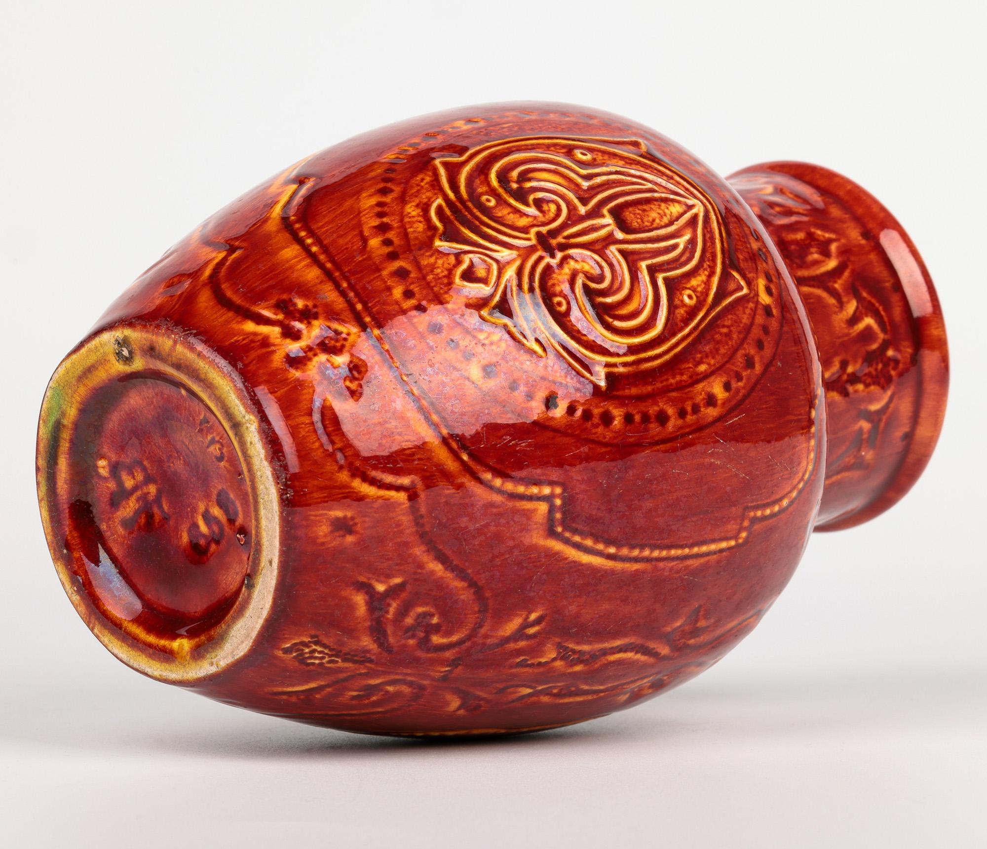 Raro jarrón de cerámica artística Burmantofts Faience con flor de lis esmaltada en rojo y amarillo Fines del siglo XIX en venta