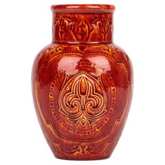 Raro jarrón de cerámica artística Burmantofts Faience con flor de lis esmaltada en rojo y amarillo