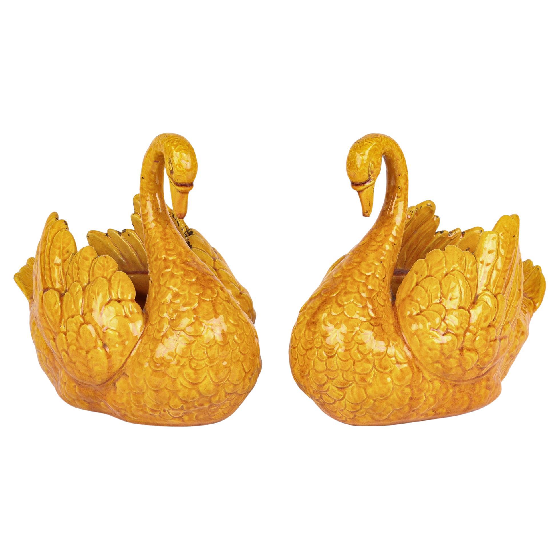 A rare pair Burmantofts Faience art pottery vases or planters modelled as swans dating from around 1890. This stylish pair of swans are modelled as swimming and stand on an unglazed irregular oval shaped foot rim with slightly recessed bases. The