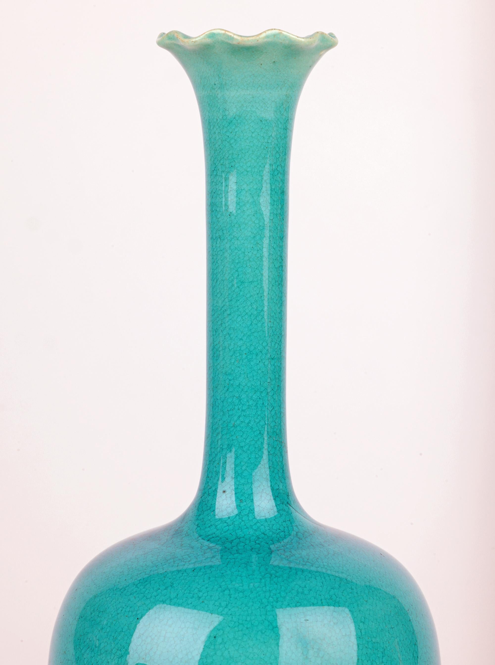 Eine hohe und elegante Solifleur-Vase aus Burmantofts Fayence-Kunstkeramik mit leuchtenden türkisfarbenen Glasuren aus der Zeit um 1890. Diese atemberaubende, leicht getöpferte Steingutvase steht auf einem schmalen, runden, unglasierten Fuß mit