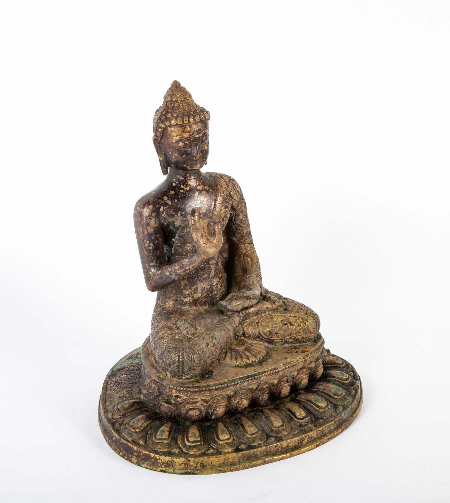 A benevolent depiction of Buddha, in a graceful lotus posture, his hands in vitarka mudra with a serene and blissful smile on his face. Shown seated with a floral shawl over one shoulder, on a beautifully cast lotus petal base. Lovely variegated