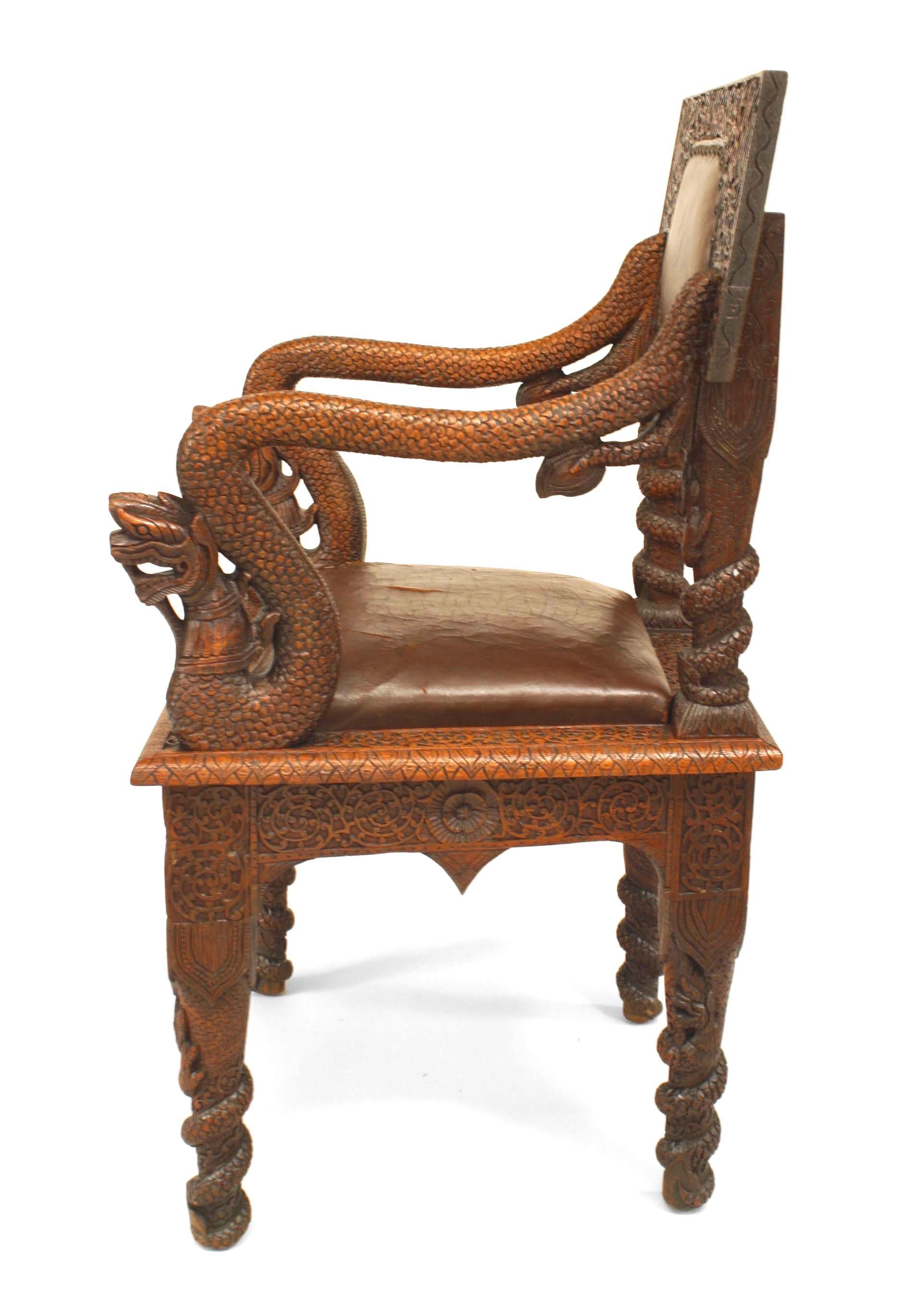 Asian Burmese-style (19th Century) carved oak armchair with decorative arms and brown leather upholstered seats and back.