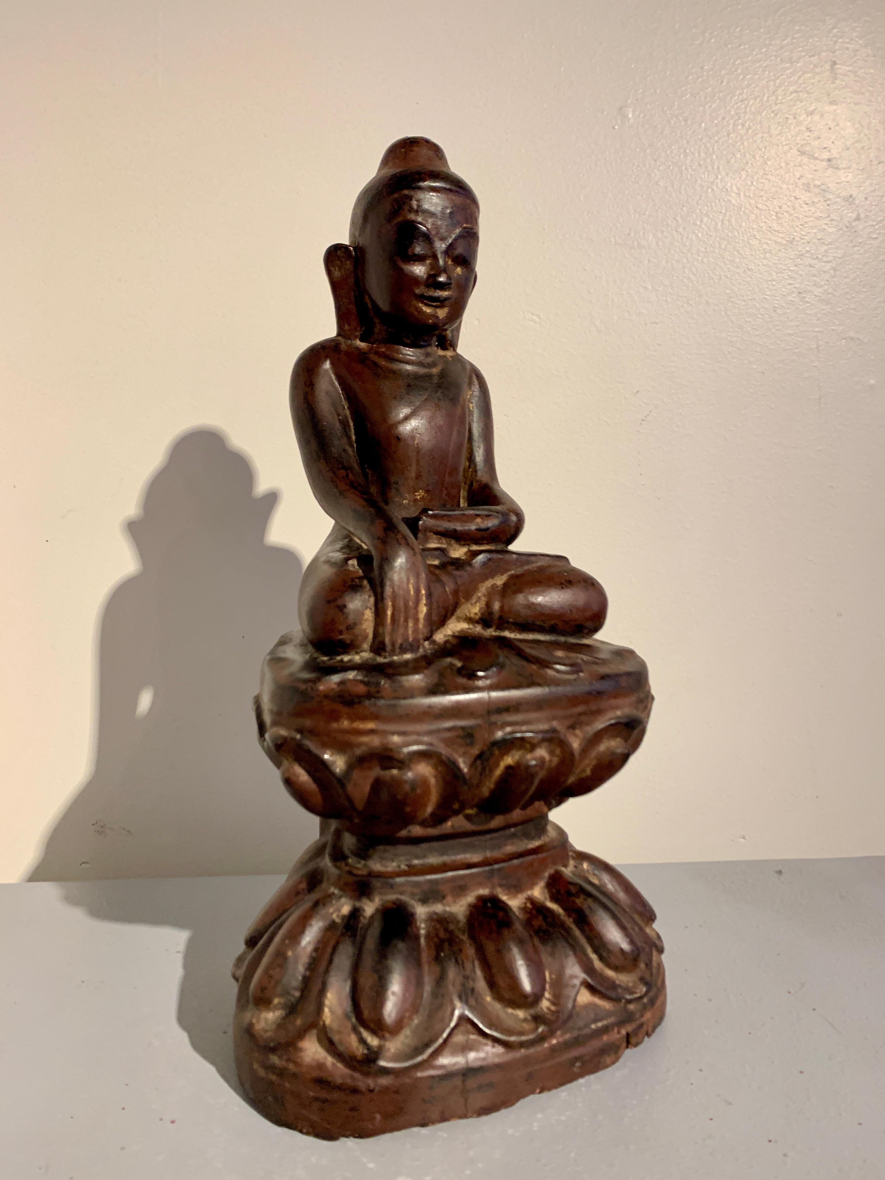 A sweet Burmese carved teak and lacquered image of the Buddha, Shan States, Ava Period, 18th century, Myanmar (Burma).

The Buddha is dressed in simple monastic robes, with one shoulder, arm, and part of his chest bare, the excess material of his