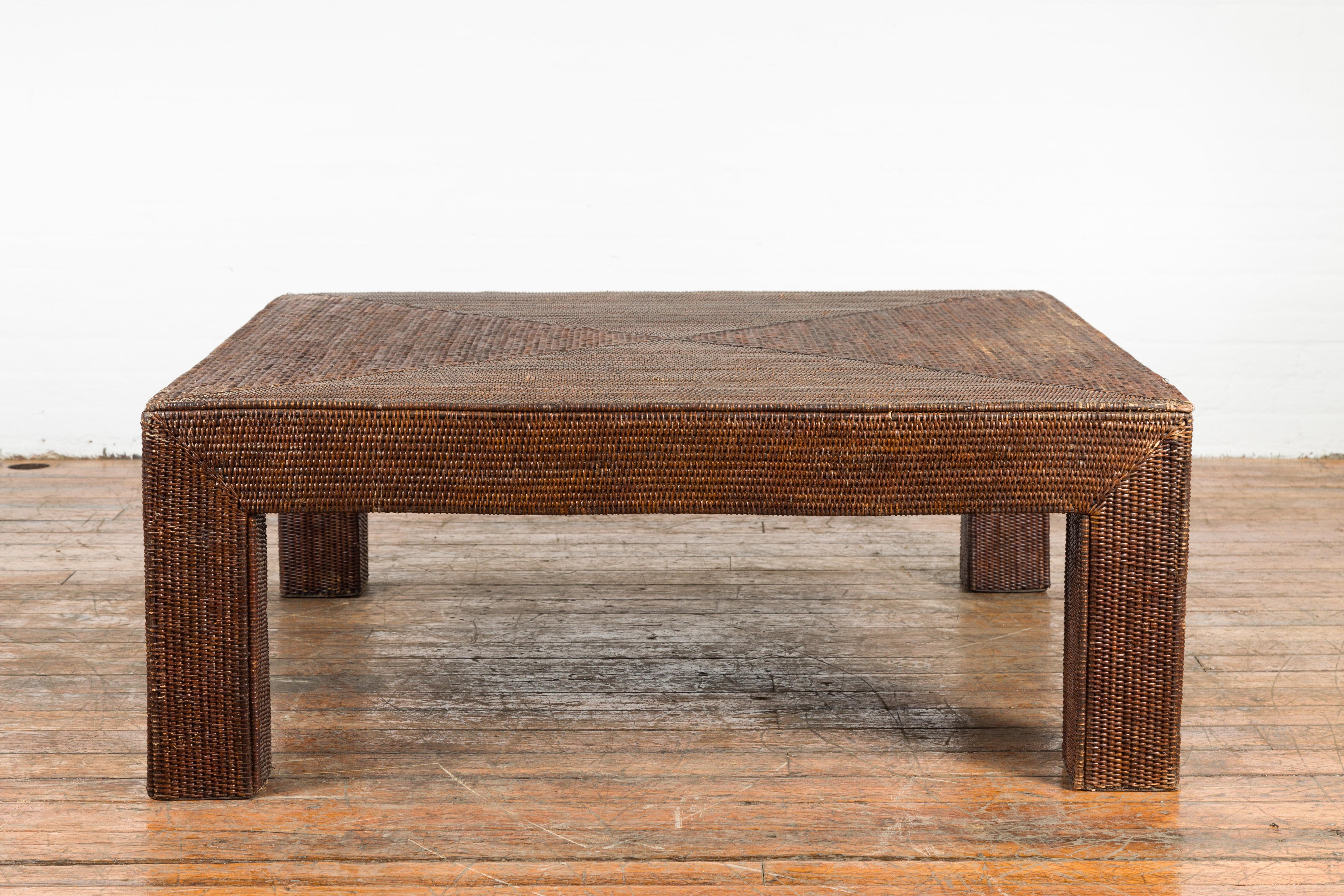 A Burmese vintage dark brown rattan parsons leg coffee table from the mid 20th century, hand-stitched over wood. We currently have several available, priced and sold $3,800 each. Created in Burma during the midcentury period, this Parsons leg coffee