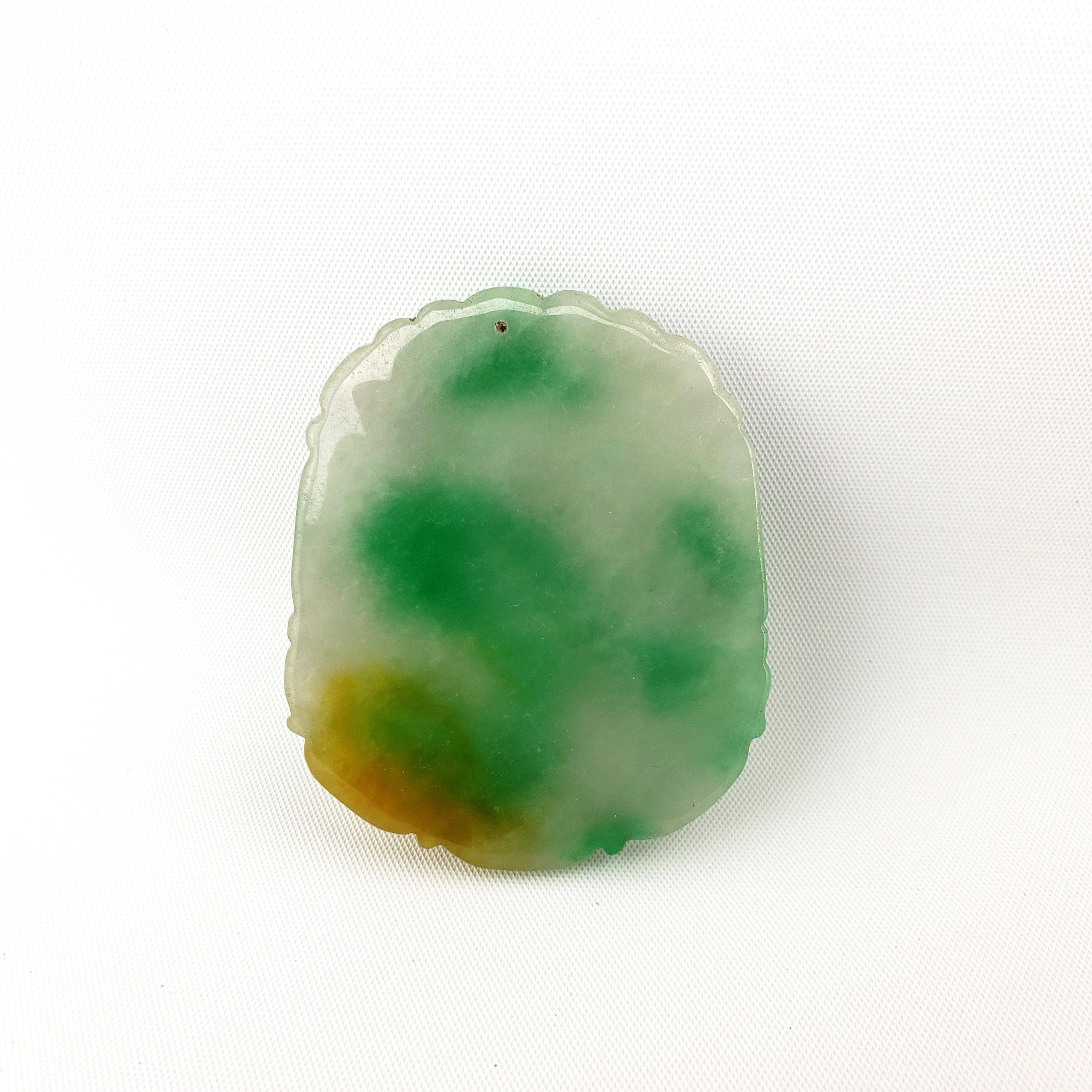 Un épais pendentif en jade sculpté dans du jade birman. Il présente une belle gamme de couleurs, notamment le jaune glacé, le vert pomme et le vert pâle du jade. Poids : 34.20 grammes.

Bijoux / Collier.