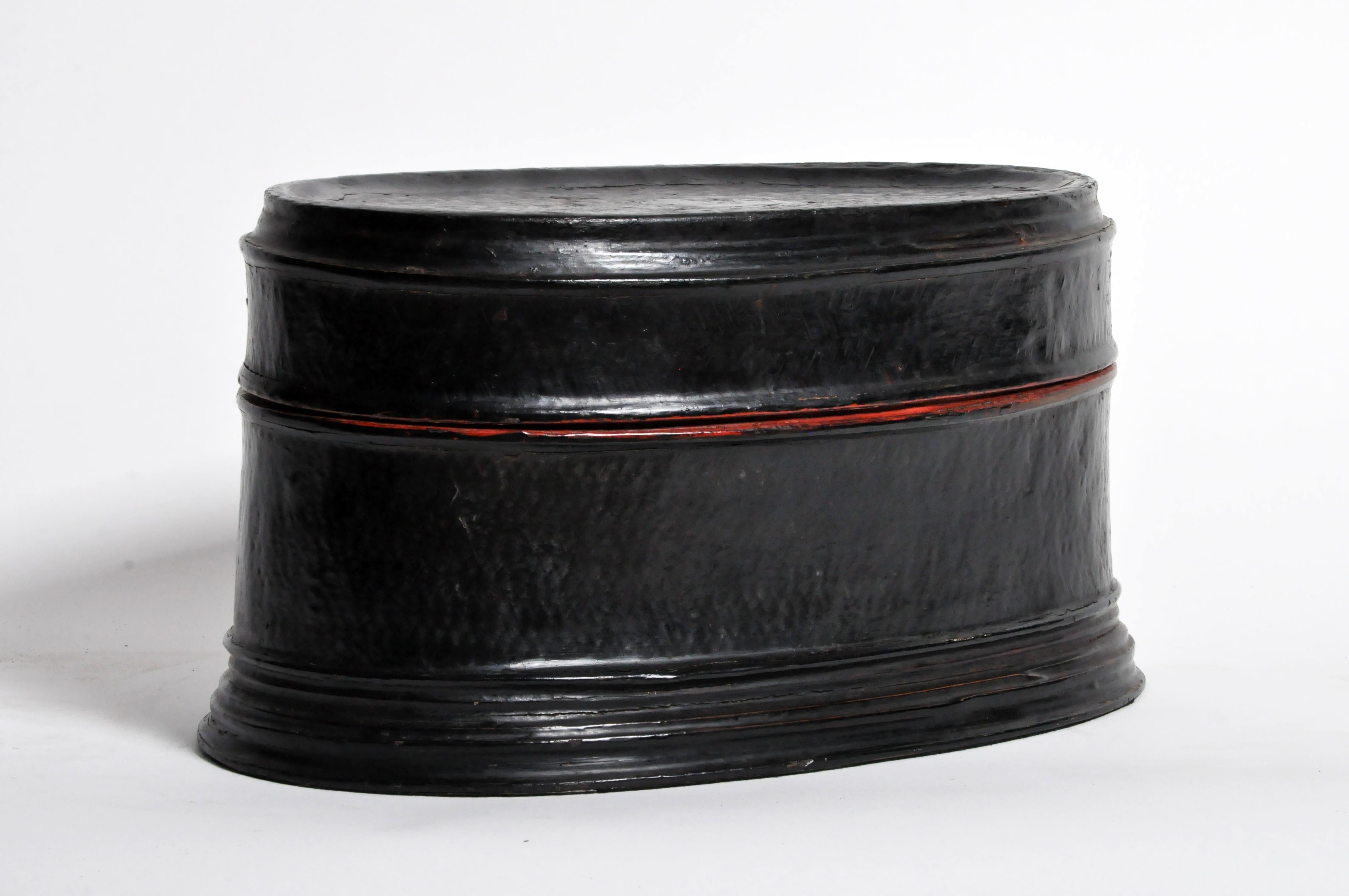 This lightweight box is made from woven rattan bonded together and sealed with red and black tree sap lacquer. It is very lightweight and break-resistant. We believe this piece is from central Burma but it could also be from the Shan States. Red