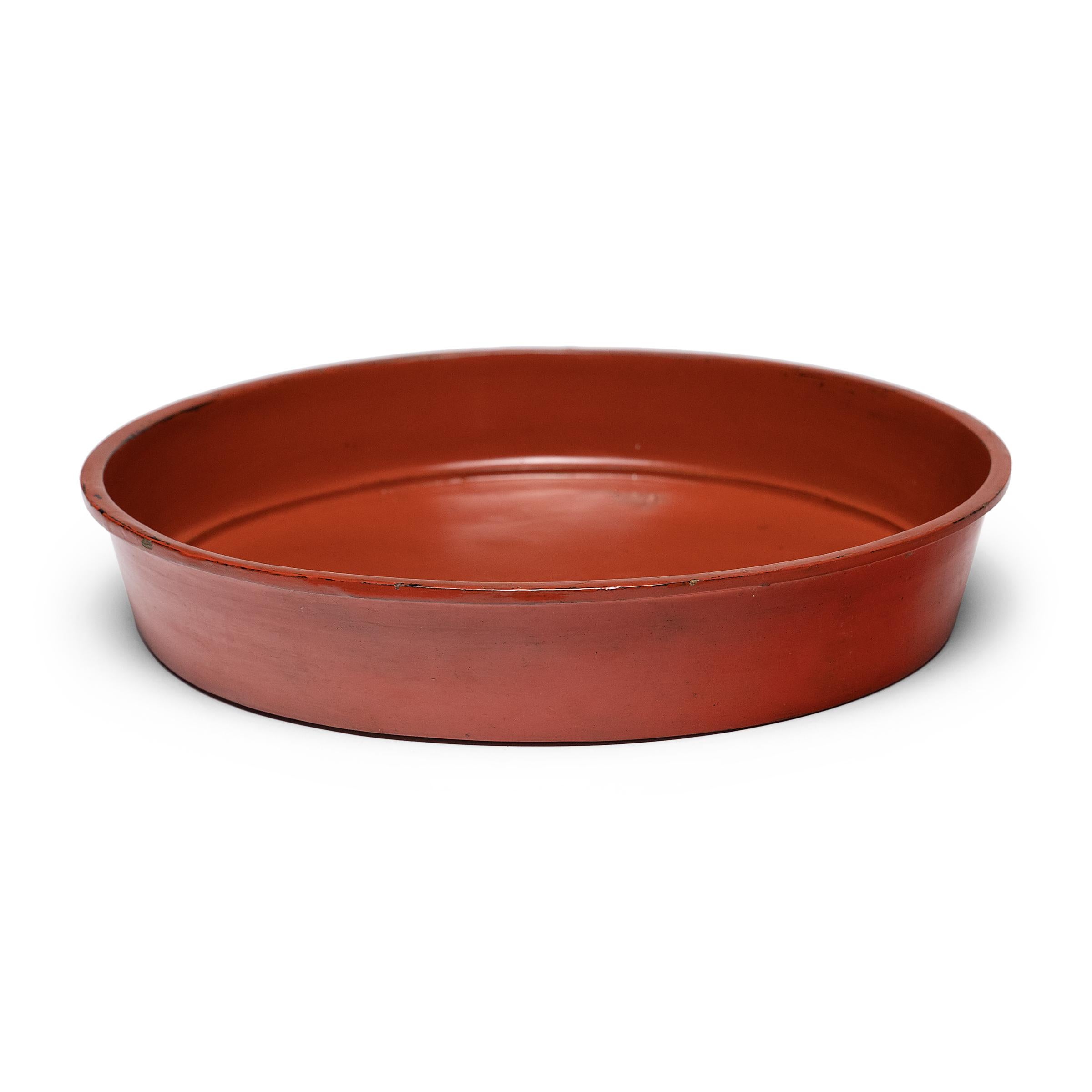 This large, round tray dates to the early 20th century and is a simple example of Burmese lacquerware (pan yun). The tray is formed of thin bamboo strips that have been woven and coiled into shape, held in place with a putty of lacquer resin