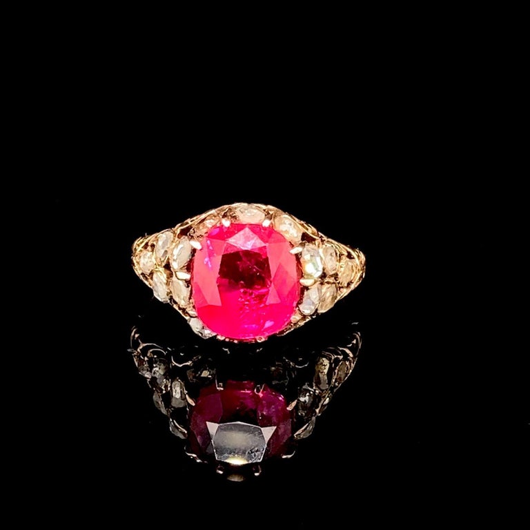 Beautiful Burmese Ruby and Diamond Gold Ring, Georgian, ca. 1800.

The unheated cushion-shaped Burmese ruby, 3.34cts, set within naturalistic trellis work, filled with 16 old-cut diamonds; of slight bombé shape.

Unmarked.

Authenticity of unheated