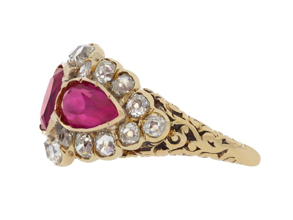 Burmese Ruby and diamond cluster ring. Set to centre with one cushion shape old cut natural unenhanced Burmese ruby in an open back rubover and grain setting with an approximate weight of 0.90 carats, flanked by two drop shape old cut natural