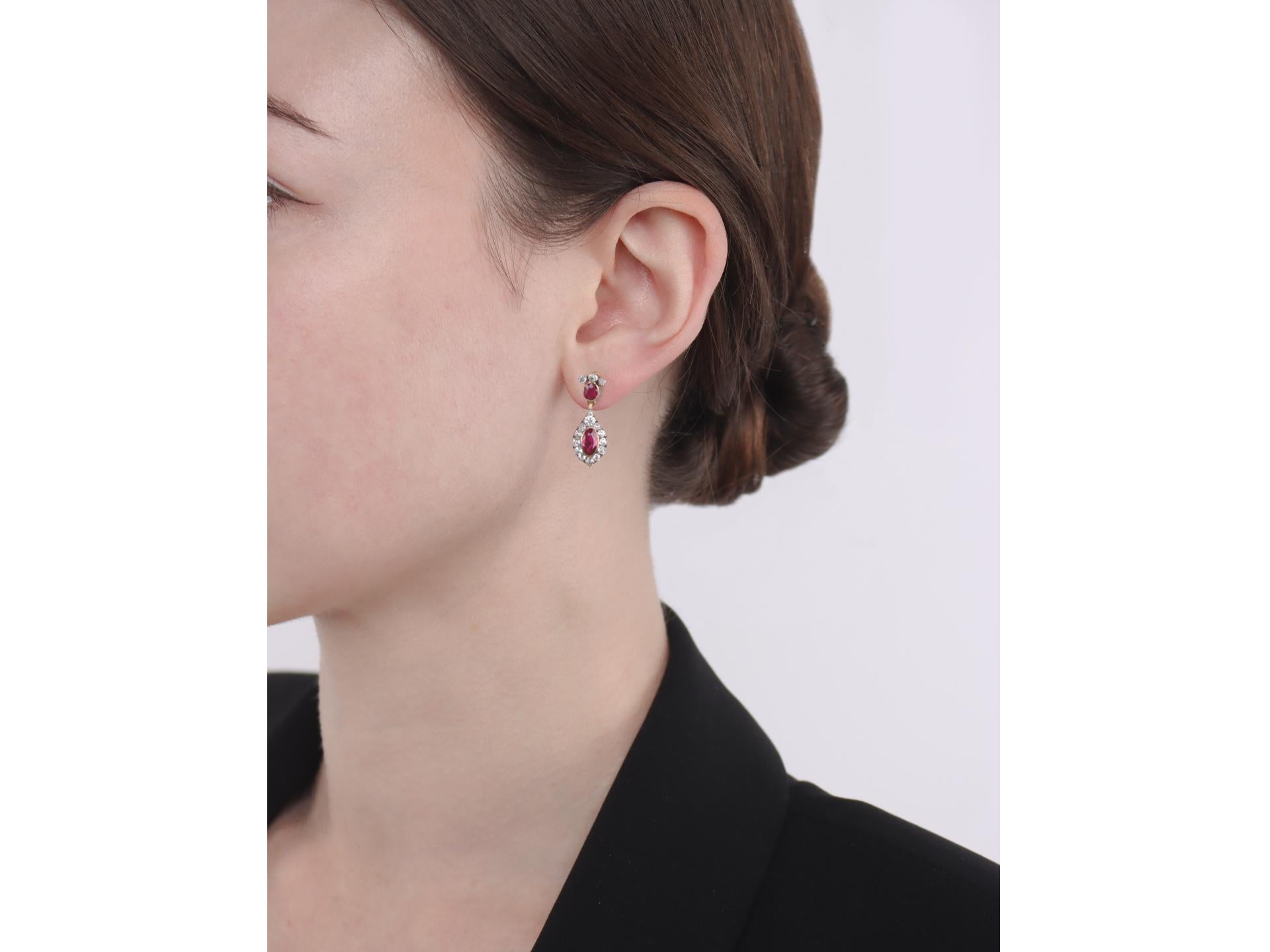 Burmese ruby and diamond drop earrings. A matching pair of earrings, each set with two oval old cut natural unheated Burmese rubies in open back rubover settings, four in total with a combined approximate weight of 2.20 carats, each decorated with