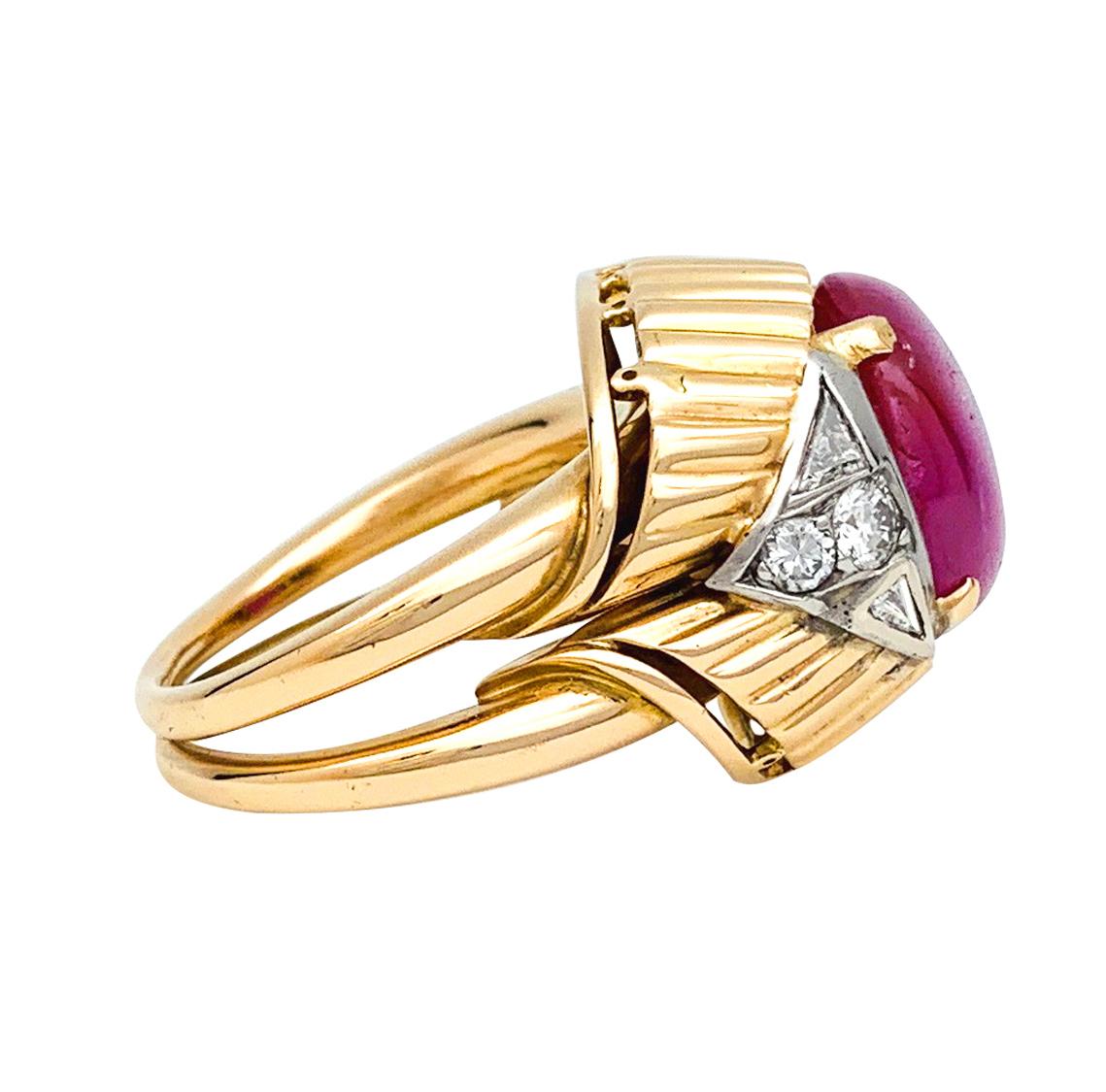 A 18Kt yellow gold and platinum ring, centered with an about 6,40 carats ruby cabochon, framed by four triangular diamonds and four brilliant cut diamonds. 
French gemological Laboratory certificate stating that the stone is from Birmanie, unheated