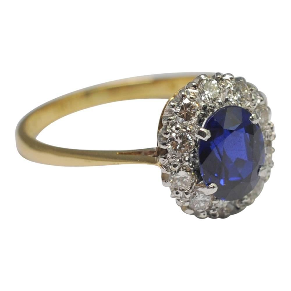 Burmese sapphire and diamond cluster ring; the royal blue sapphire is Certificated as Burmese, untreated and is surrounded by brilliant cut diamonds totalling 0.30ct.  The diamonds are set in platinum with the shank in 18ct gold.  Stamped Plat 18ct.