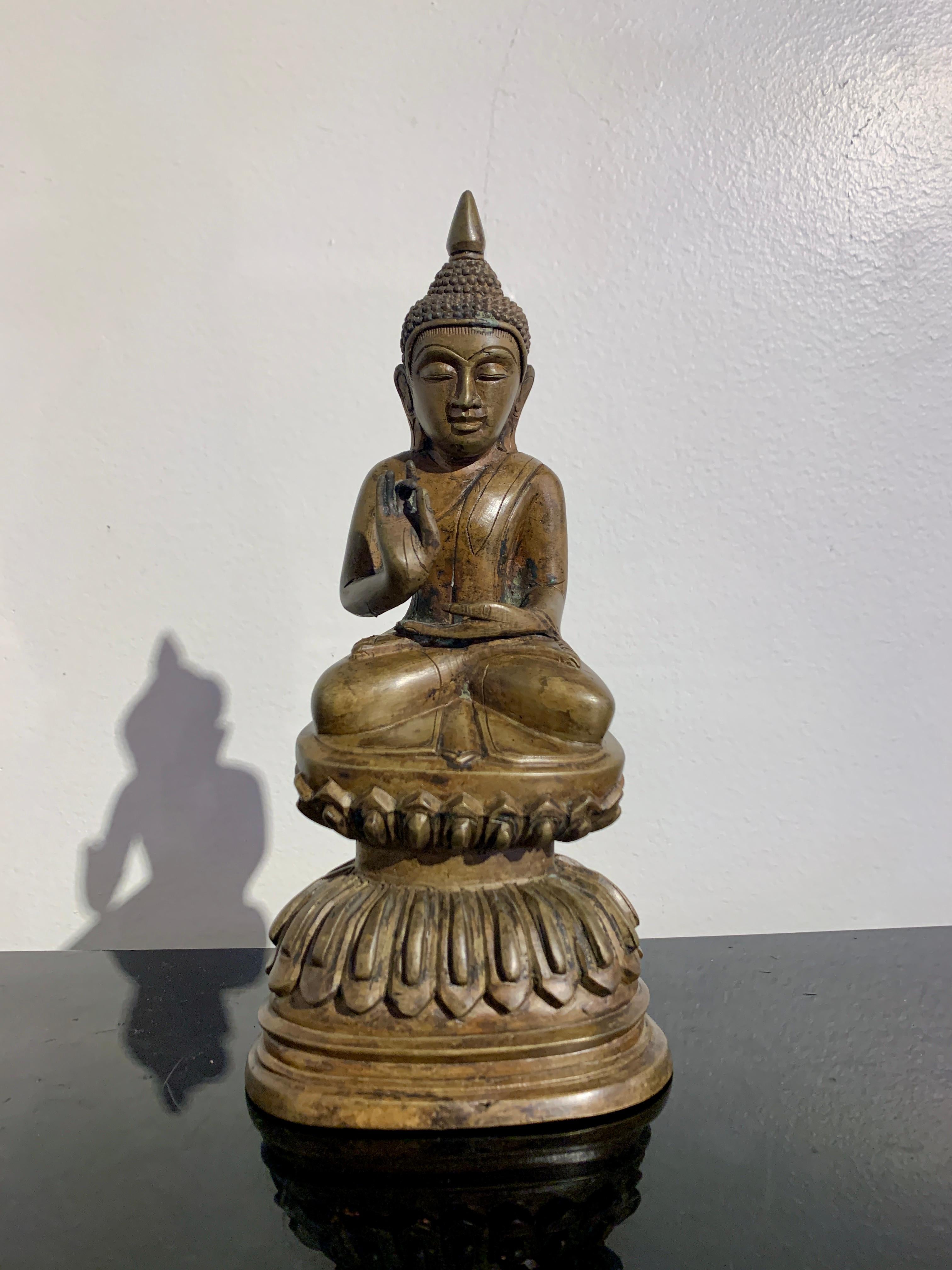 Un delizioso Buddha seduto in bronzo fuso di origine birmana Shan in stile Ava, fine XIX o inizio XX secolo, Birmania.

Il Buddha siede su un piedistallo a doppio loto alto e ben fuso. È seduto inclinato in avanti nella posizione del loto
