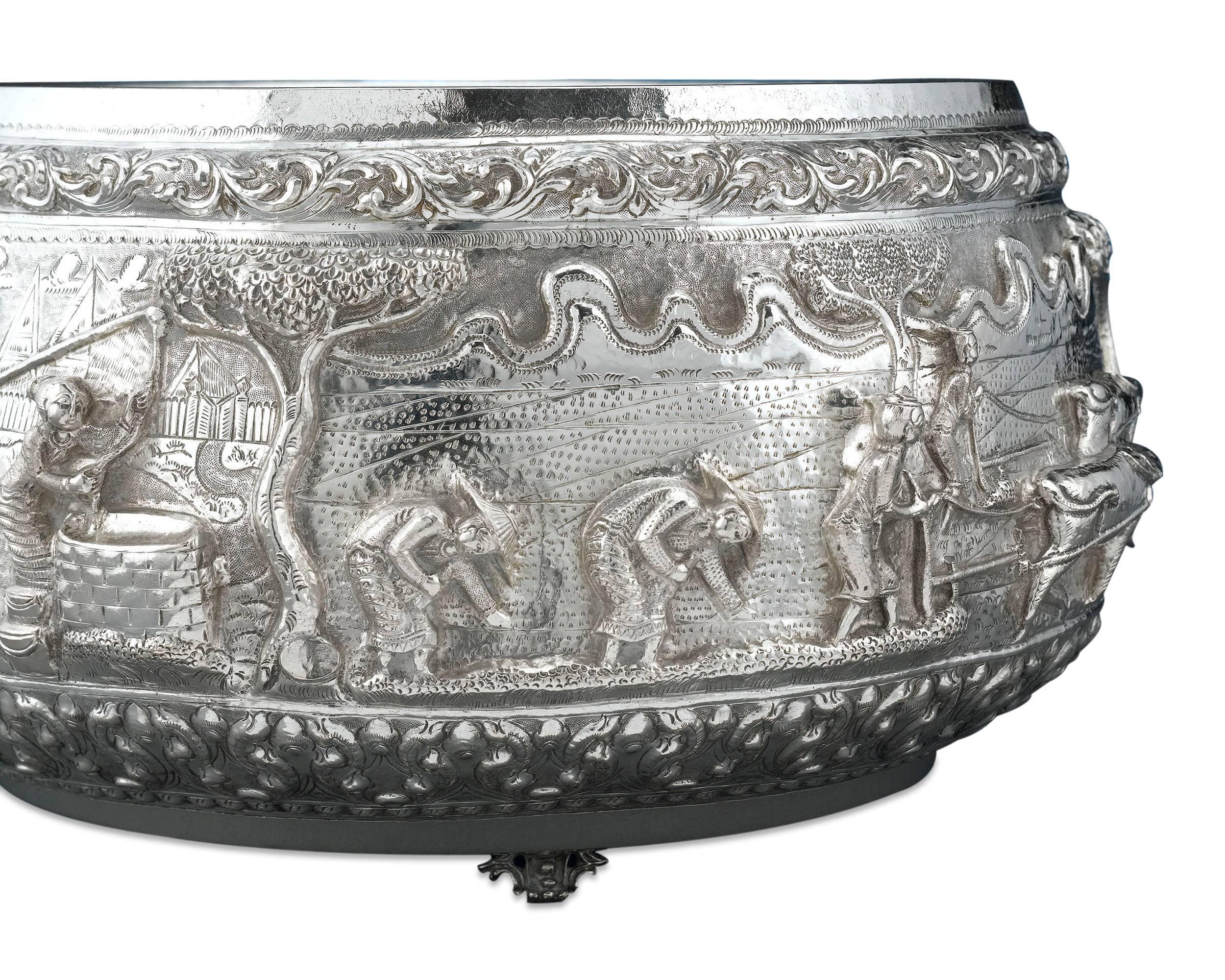 This unusually large Burmese silver bowl is most certainly the work of a master artist. A tour-de-force of silver hailing from Burma, or Myanmar, this bowl exhibits some of the most magnificent high-relief repoussé decoration. A continuous tableau