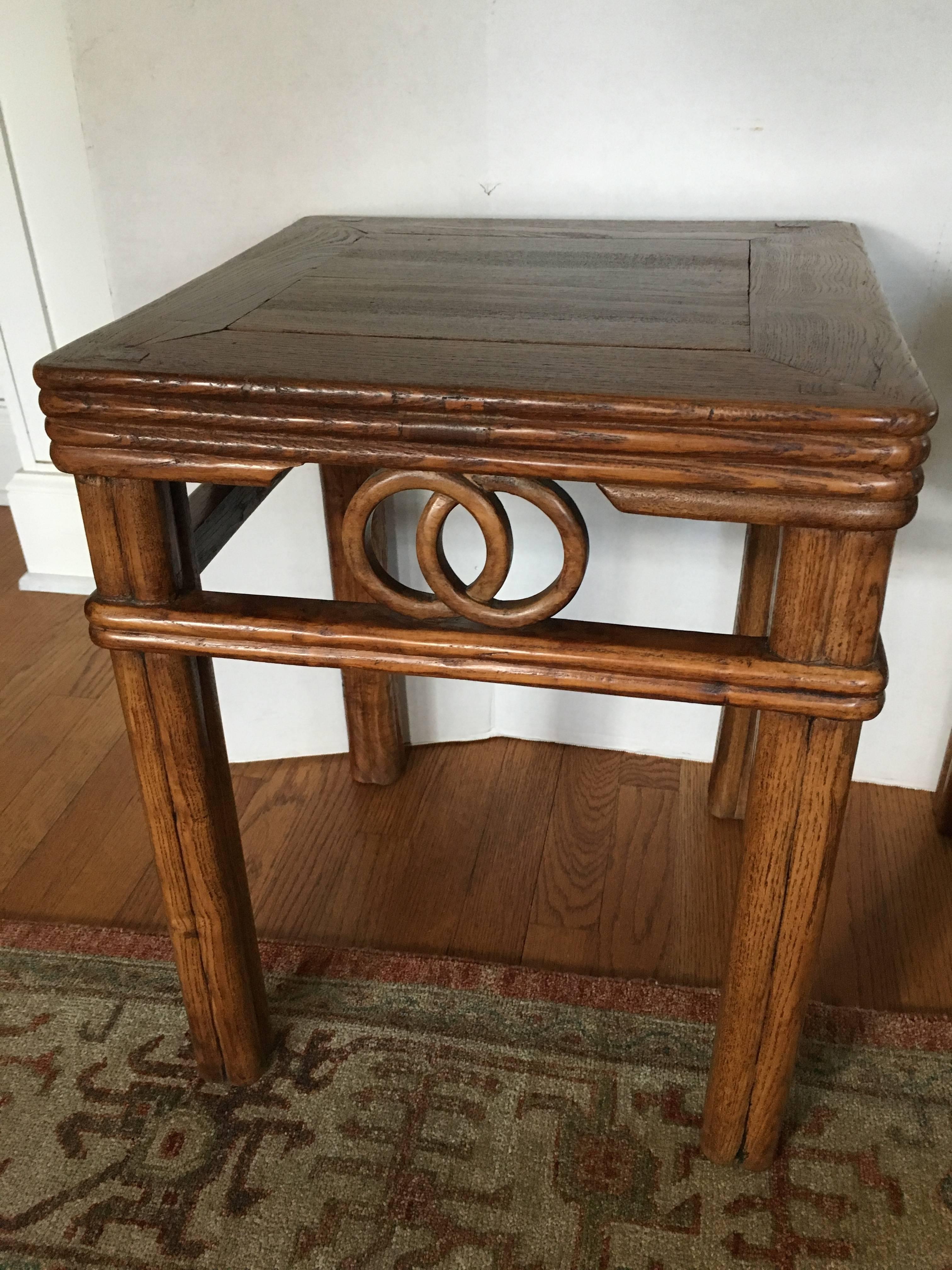 A pair of Chinese wood side tables with a wedding band motif.