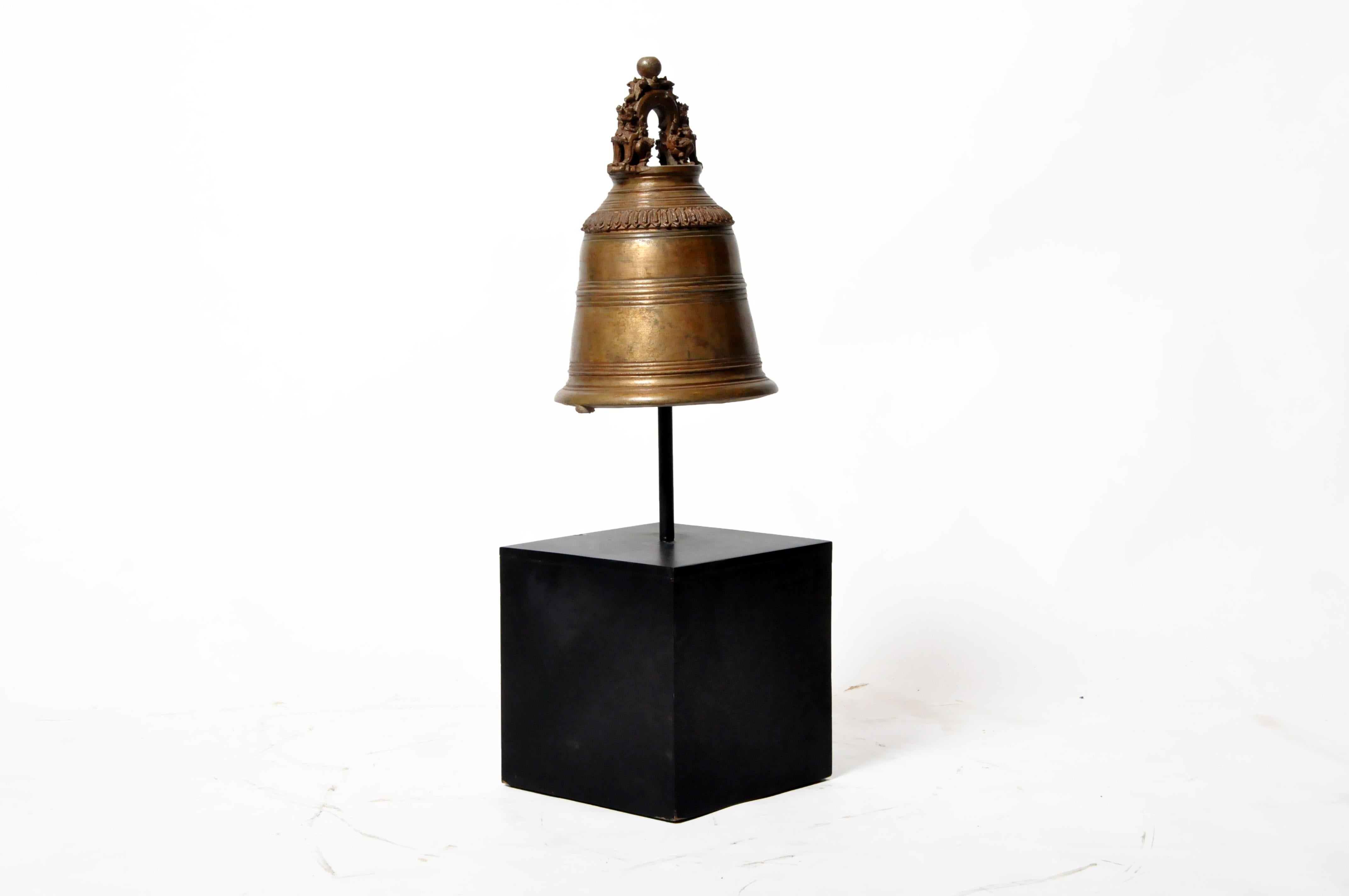 This brass bell was given to a temple as an act of merit-making. It was suspended from a heavy cord and rung on ceremonial occasions. The piece dates to the early 20th century and came from central Thailand. Wear consistent with age and use.
  