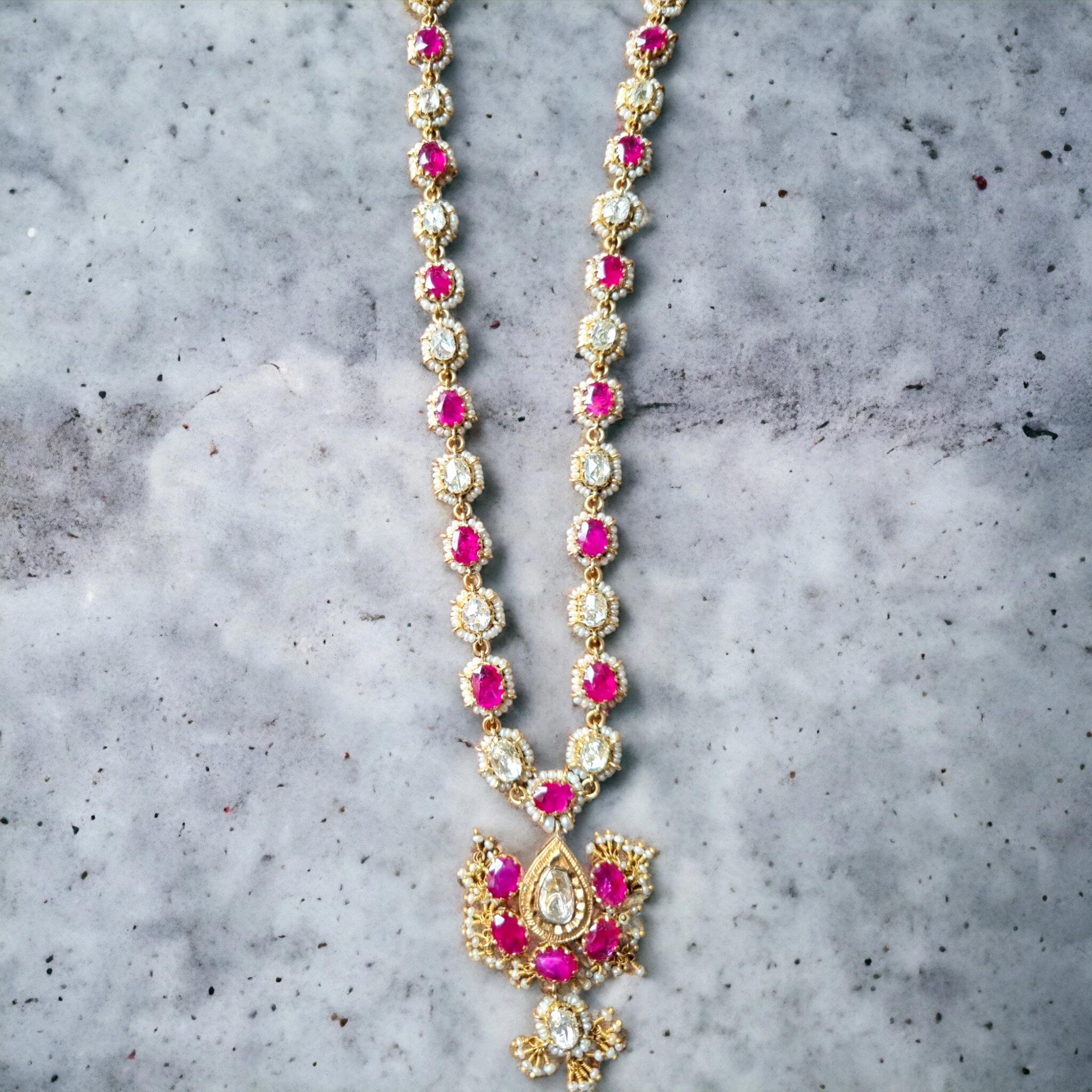 OLD BURMA (MYANMAR) UNTREATED, UNHEATED RUBY, ROSE CUT DIAMOND AND SEED PEARL NECKLACE. LATE 19TH CENTURY. (Gujarat, India)

Consisting of a pendant centrally set and designed as an alternating series of oval-cut ruby and old-cut diamond clusters,