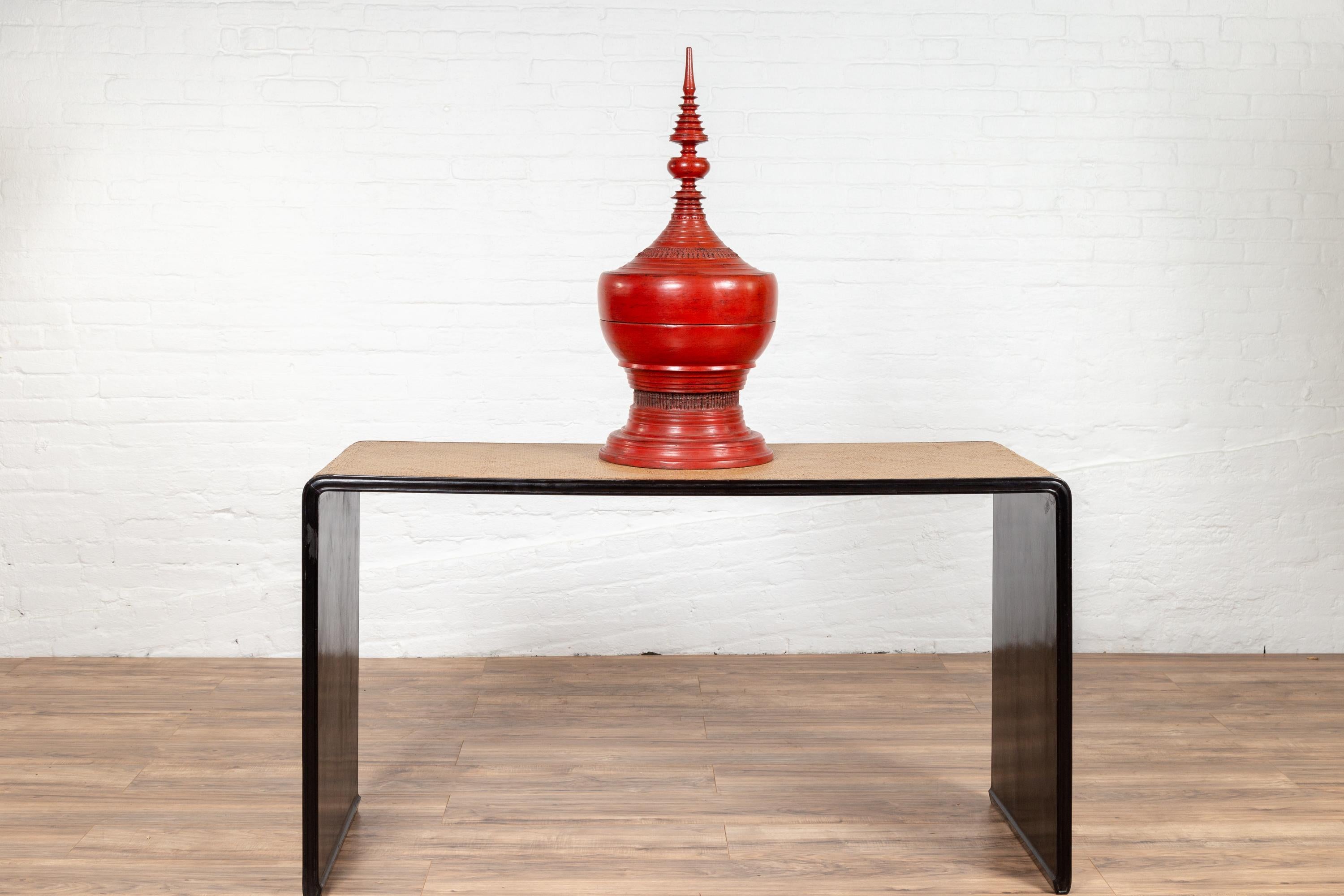 A vintage Burmese waterfall console table from the mid-20th century, with black lacquer frame and rattan top and sides. This simple yet elegant Burmese table features a clean Silhouette, presenting a black lacquered waterfall wooden frame supporting