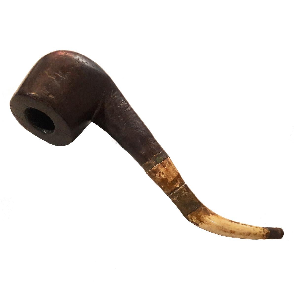 A large tobacco pipe from old Burma (Myanmar), circa 1850. Solid wood bowl, chamber and shank. The stem is made of bone, attached to the shank by a mortise in solid brass, and a lip made of brass. All parts are detachable. 

This antique pipe
