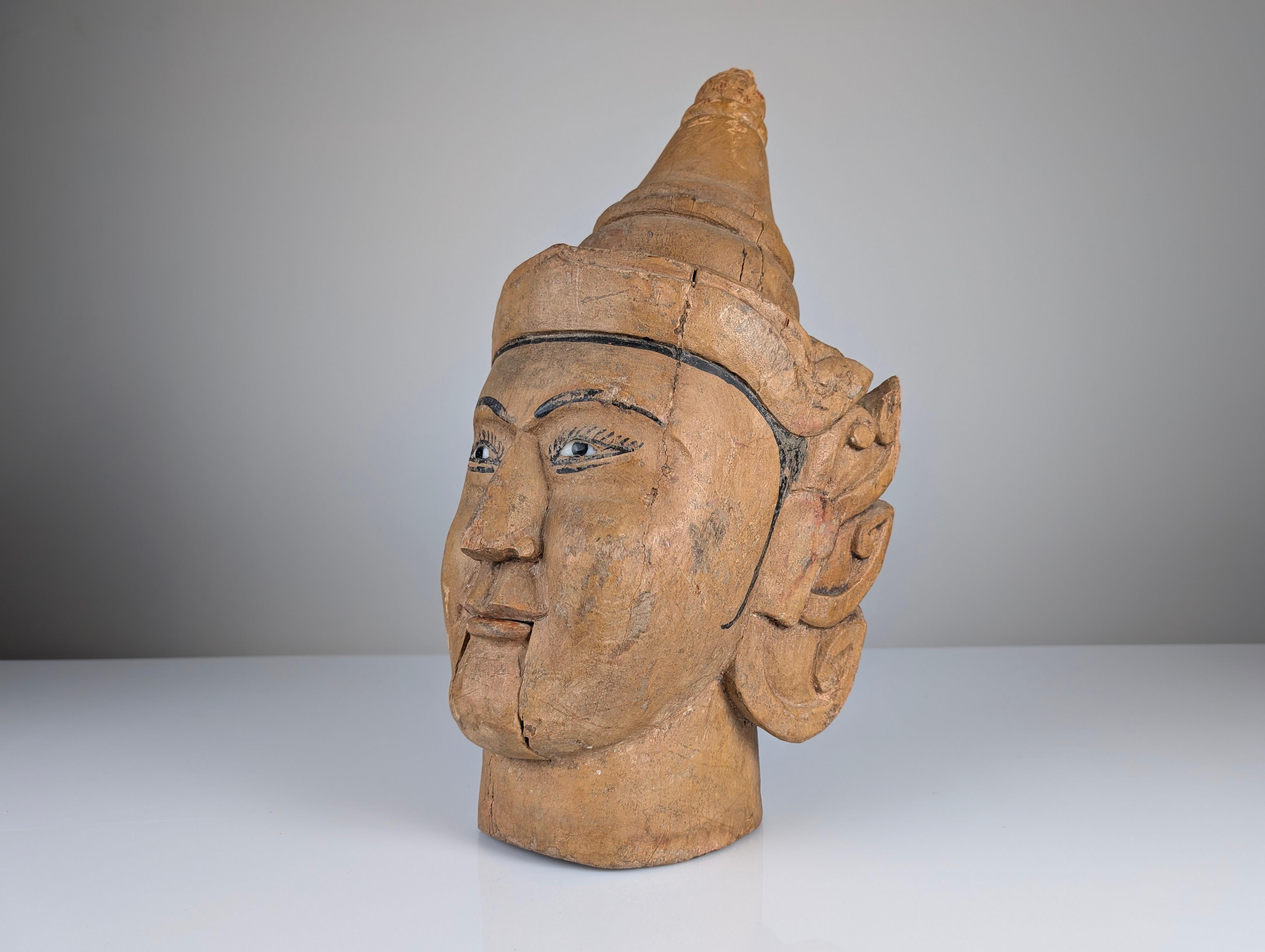 This intricately carved wooden puppet head, originating from Burma (Myanmar), is a captivating example of traditional Burmese puppetry. Crafted during the 20th century, the puppet features a functional mouth-opening mechanism, which was used in