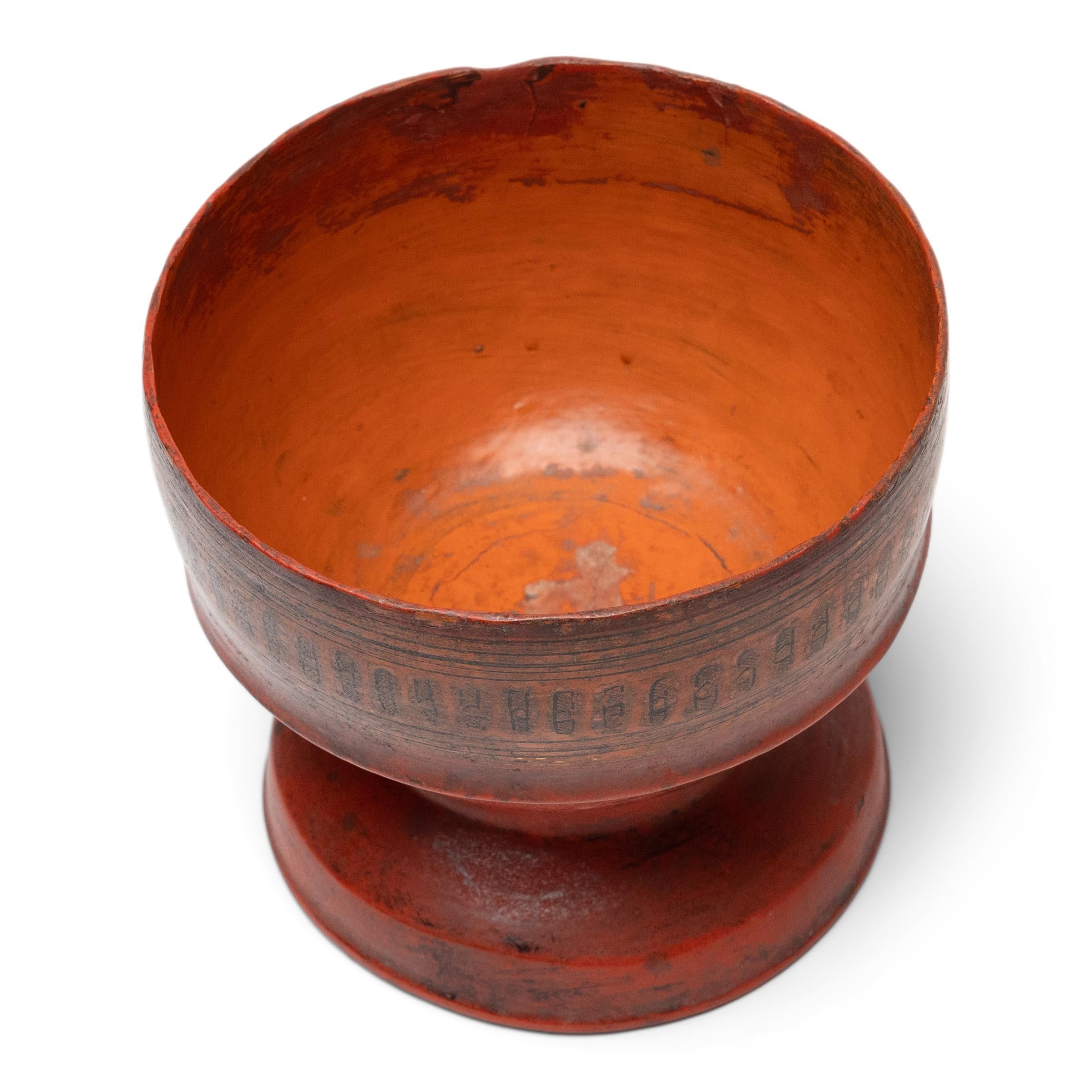 Rich with character and antique texture, this Burmese lacquer presentation bowl dates to the late 19th century and is a beautiful example of a traditional craft. A band of etched linework decorates the sides in the manner of 