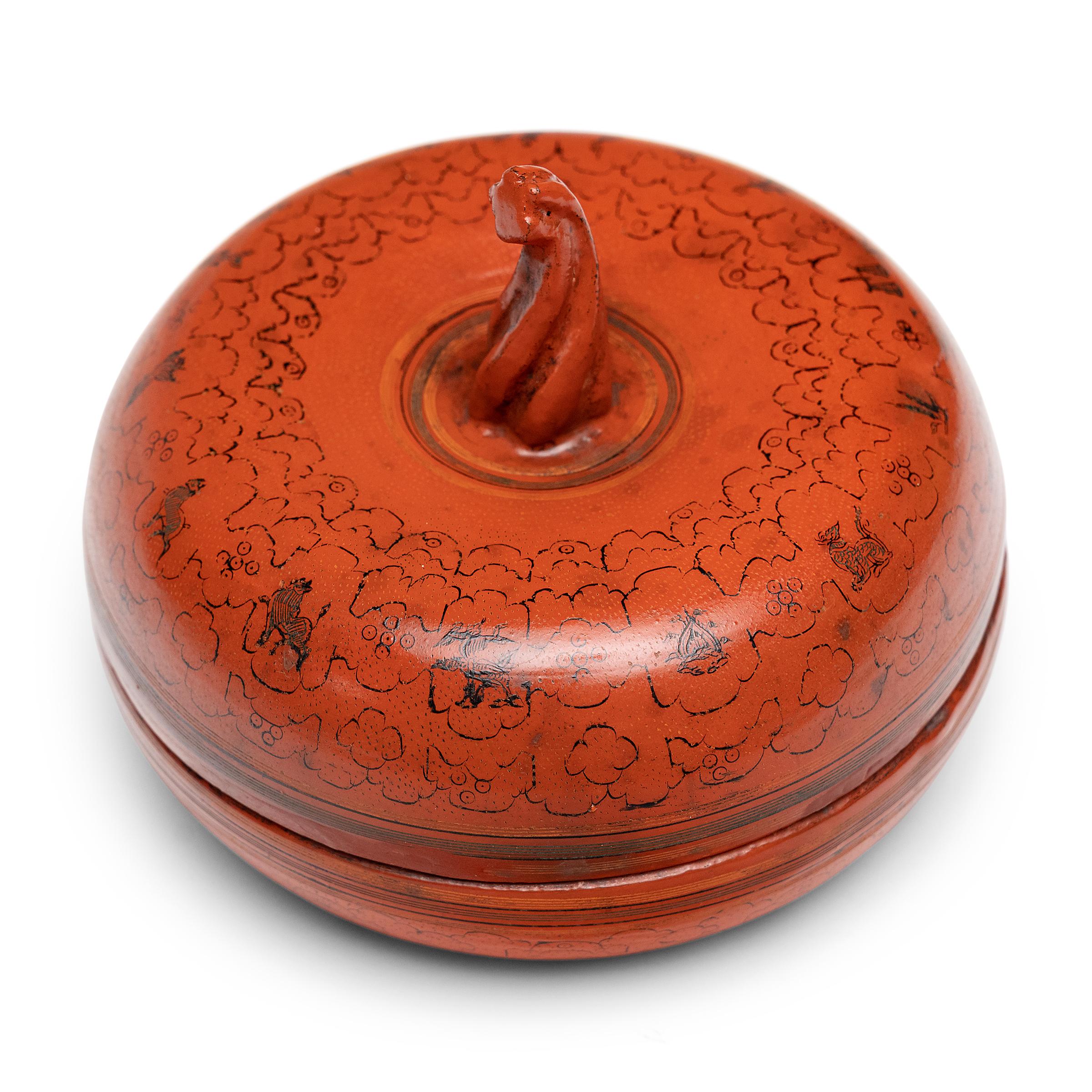 This late 19th century Burmese red lacquer box is sculpted in the shape of a gourd, pumpkin or melon, a fruit thought to carry blessings of abundance because of its many seeds.

The surface is finely engraved in the 'yun' technique, hand-etched with