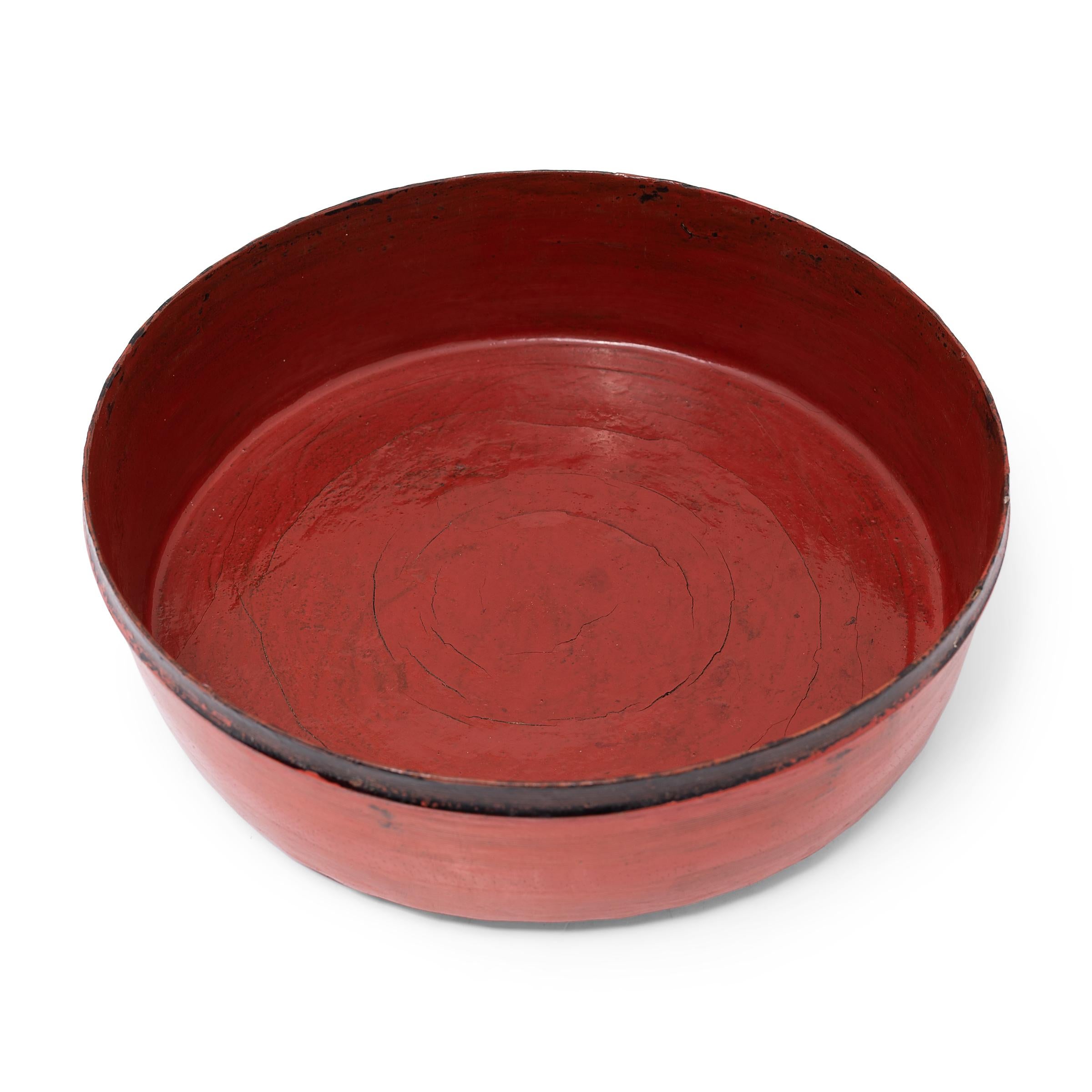 This round tray dates to the early 20th century and is a simple example of Burmese lacquerware. The tray is formed of thin bamboo strips that have been woven and coiled into shape, held in place with a putty of lacquer and sawdust, and finished with