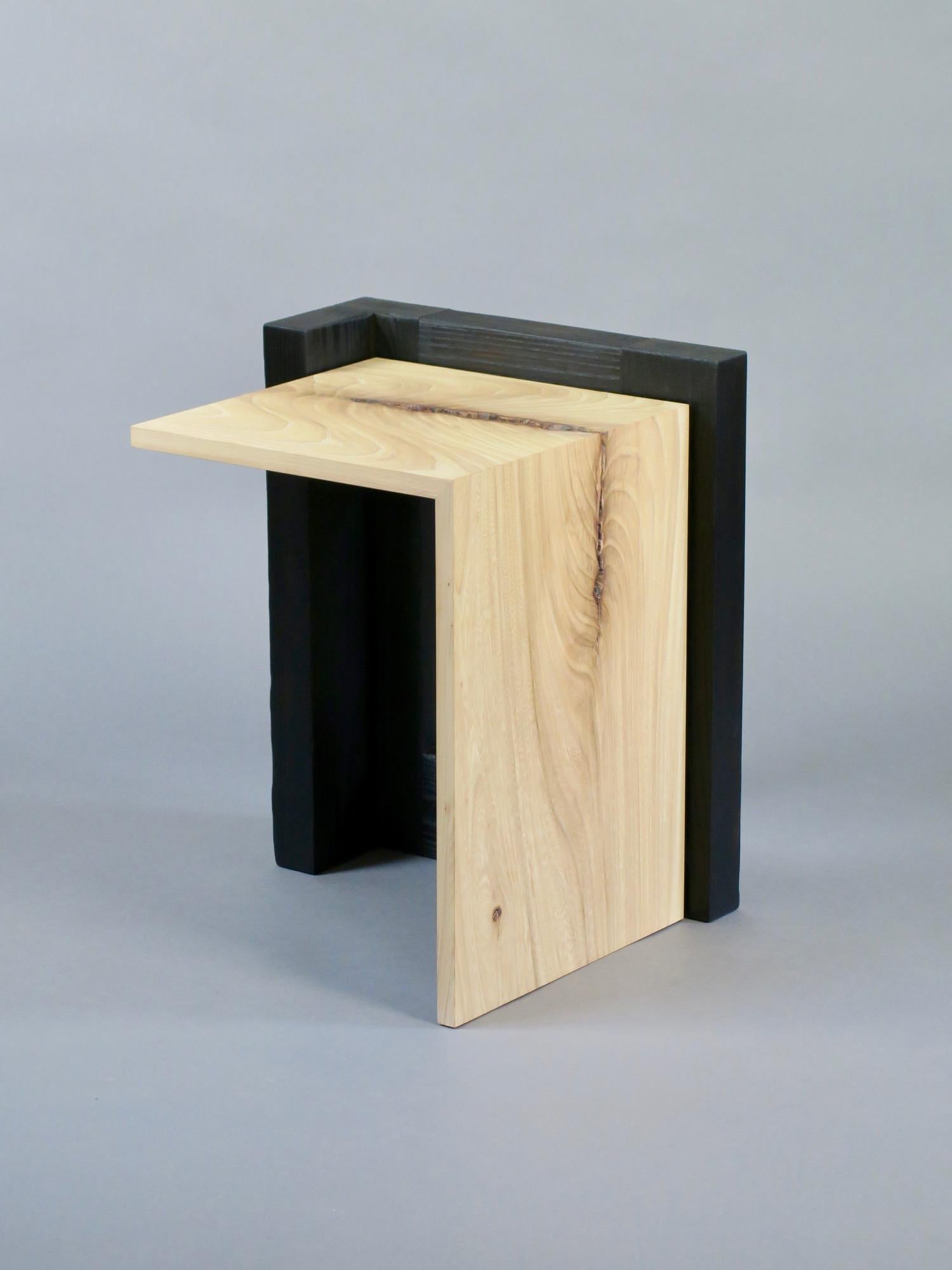 The Oriel III side table features a blackened solid ash base which has been burned in the traditional Japanese shou sugi ban technique. This technique when used on ash reveals the deep richness of the open grain and creates a unique black quality