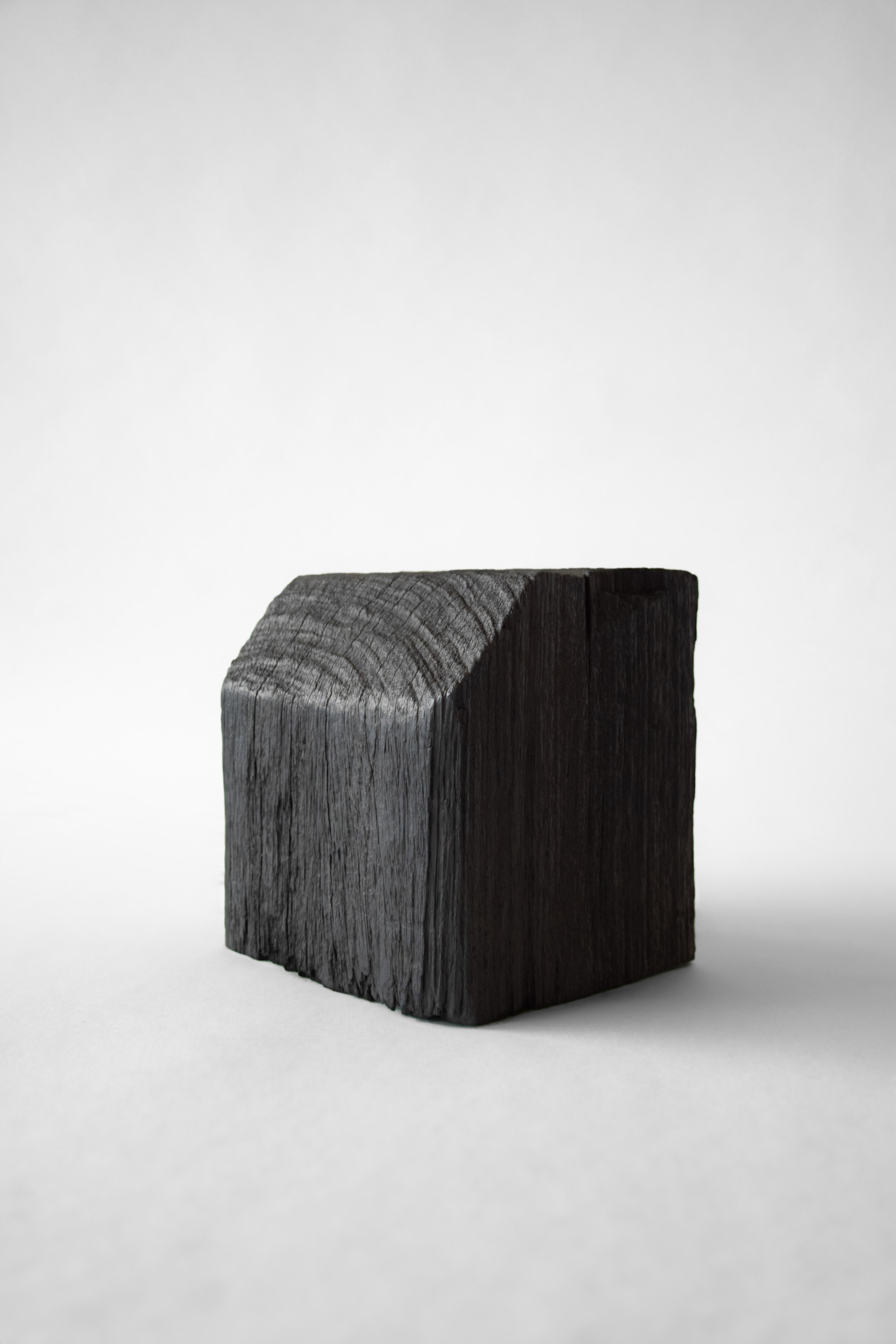 Burned Iron Wood Ortus Side Table by Eichkorn
Dimensions: W 28 x D 28 x H 25 cm
Materials: Burnt iron wood.

Ortus speaks of past and transformation. Crafted from solid ironwood, recovered from the port of Basle, it bears the marks of its own