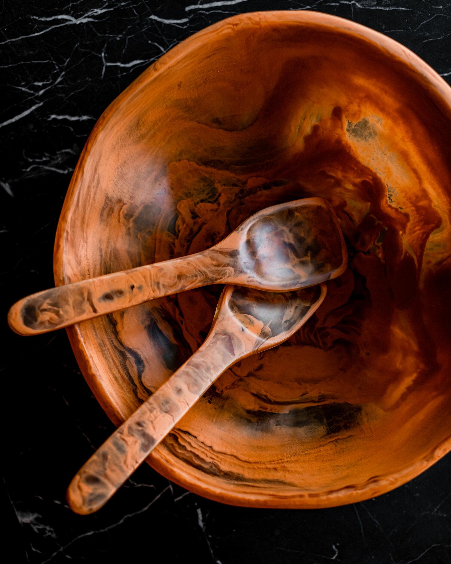 This rust colored resin bowl's shape evokes that of natural stone. and is a beautiful example of the artisanal craftsmanship that goes into each piece designed by Monica Calderon and handmade by expert artisans in Mexico. The stone resin bowl in