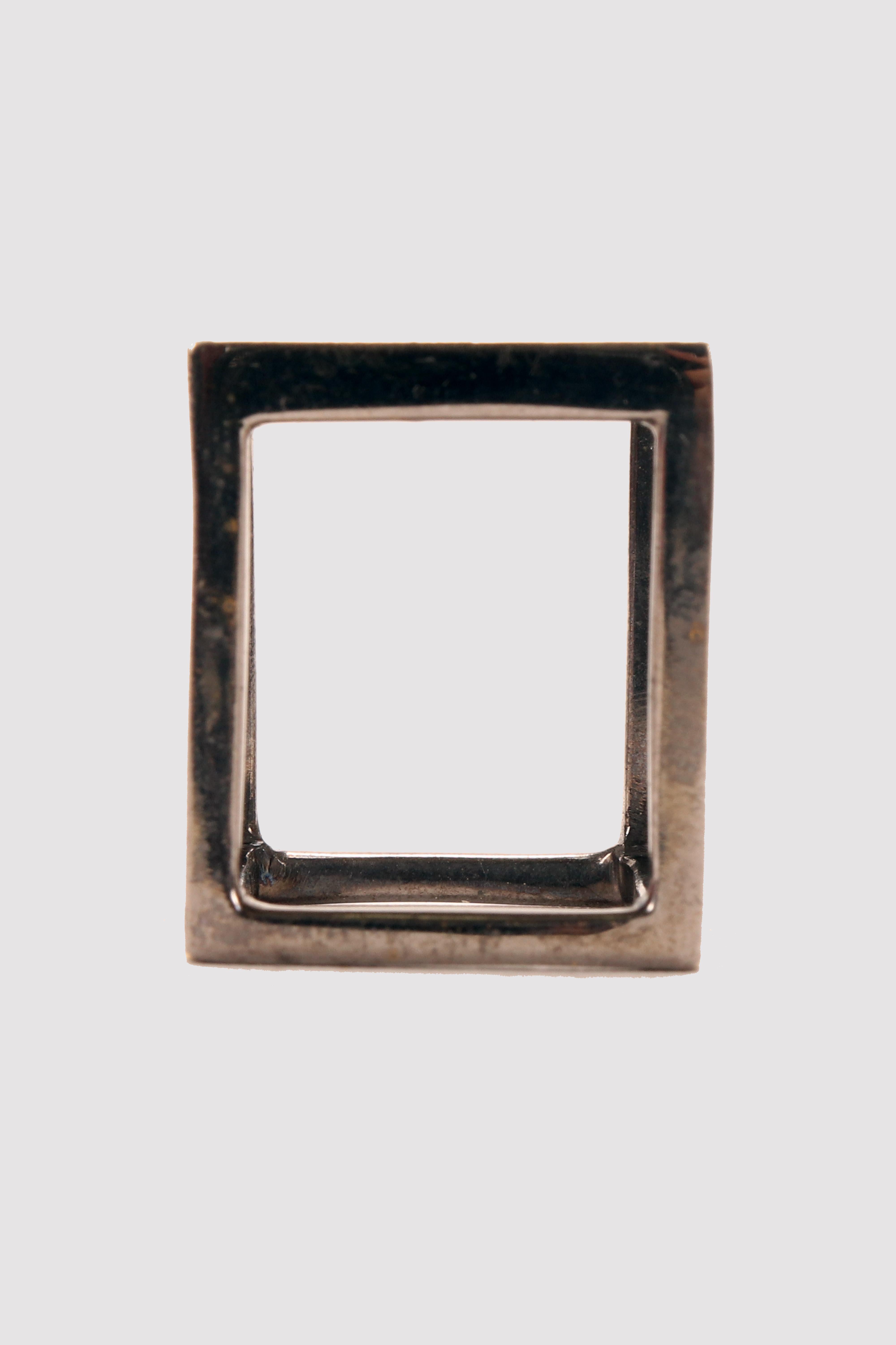 Prototype d'un anneau cubique en laiton bruni. L'une des faces du solide est une plaque de laiton bruni de forme carrée ; les cinq autres faces sont vides. Conçu par Stefania Bosio pour Ornamenta. Italie, 2000.