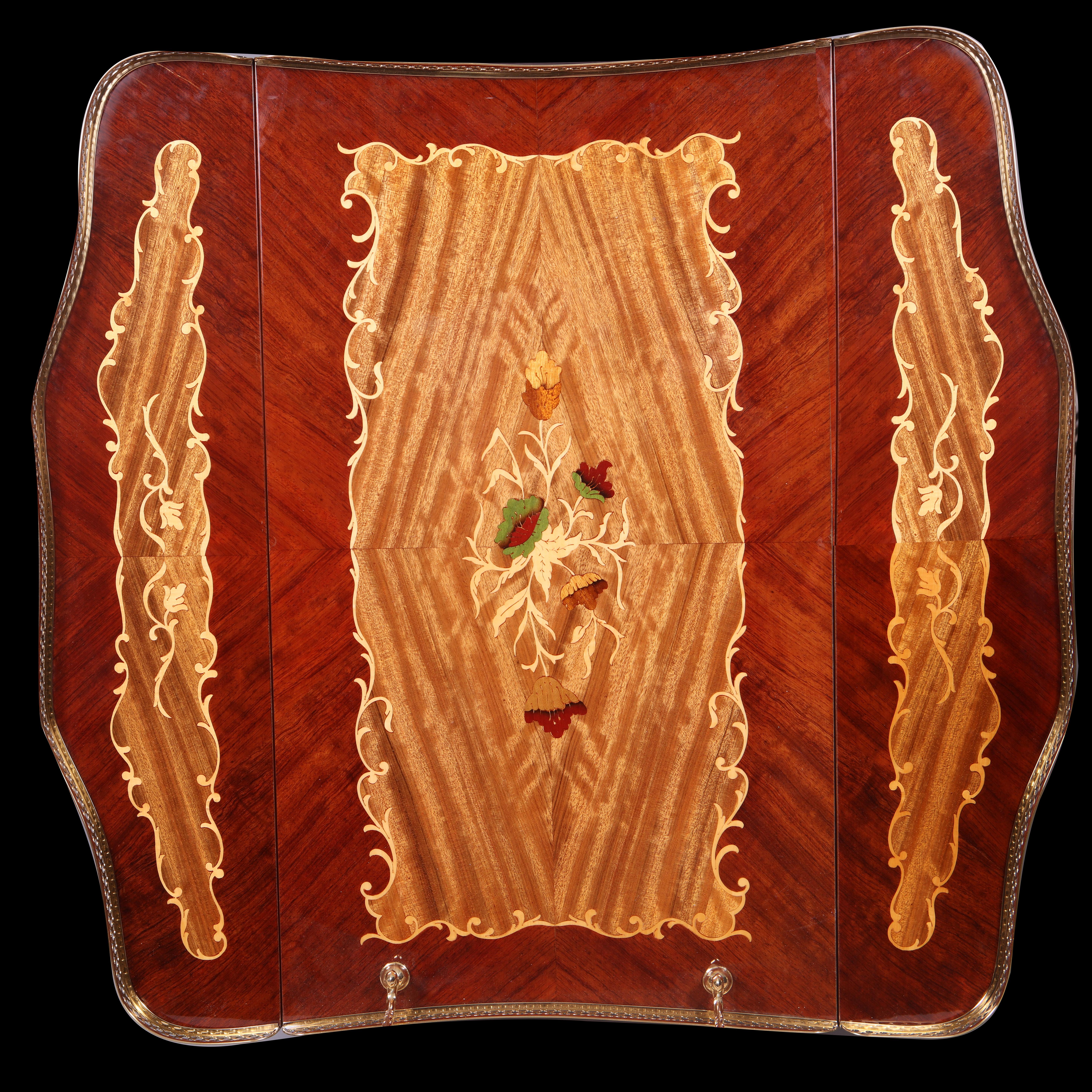Chariot à boissons du milieu du siècle très bien présenté, avec des abattants réglables pratiques, des dessus en marqueterie et des galeries en laiton bruni. Les pieds en laiton bruni et tous laqués pour protéger la surface. 

Italie, vers