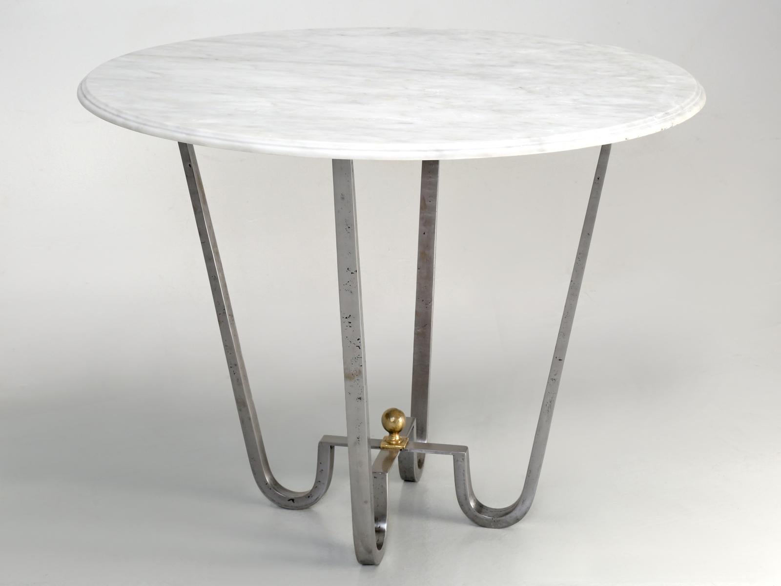 Center hall table that we hand-form from solid steel (or optionally in solid bronze of brass) and then burnish to a brilliant finish. This particular center hall table was clear-coat with an industrial protective coating and the Carrara marble top.