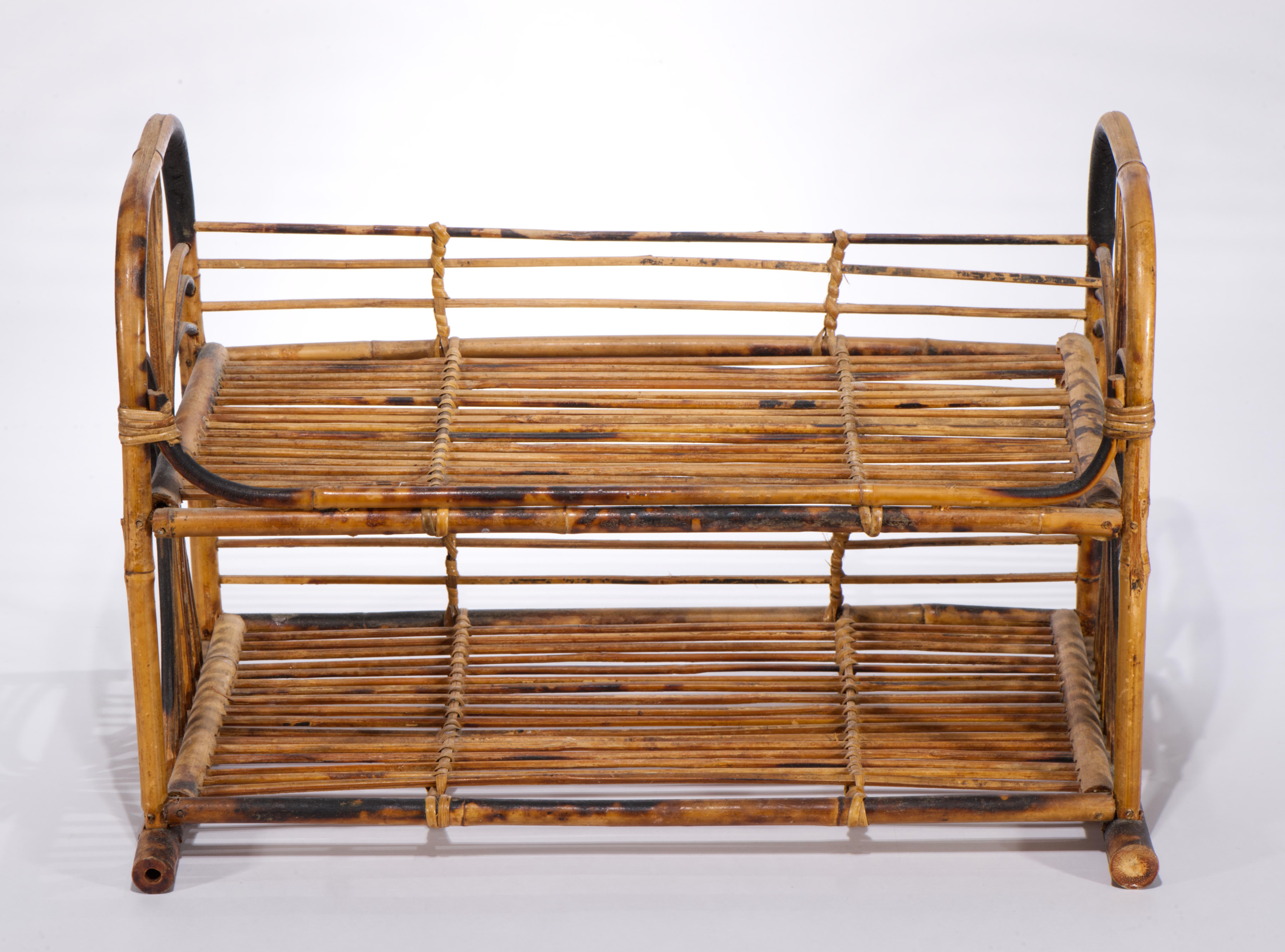  Mid Century Modern bamboo and wicker woven shelf features tiered structure of burnt or tortoiseshell bamboo with geometric bent bamboo forming the sides of the shelf; the design suggests strong Chinoiserie influence, as interpreted in Chippendale