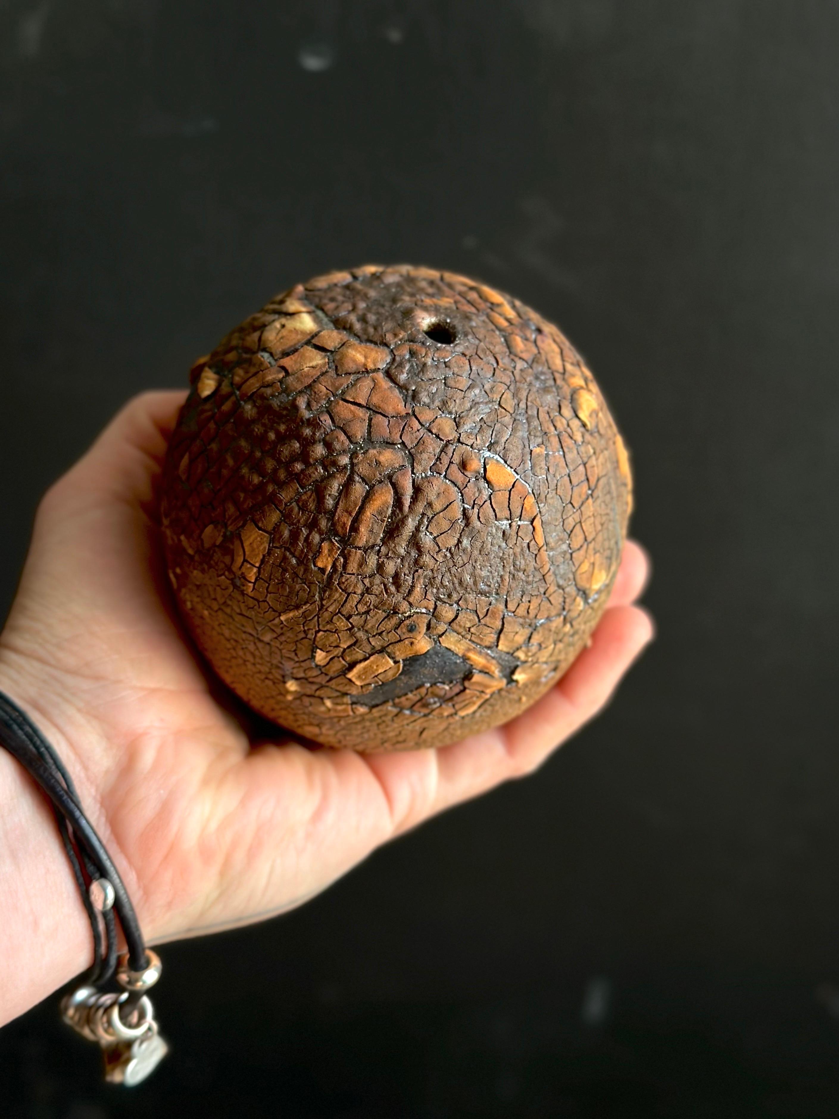 This bold ceramic vase showcases a dynamic cracked surface in warm, earthy tones, evoking the look of scorched desert ground. The striking texture and deep, warm palette make it a standout piece for industrial, modern rustic, or eclectic interiors.