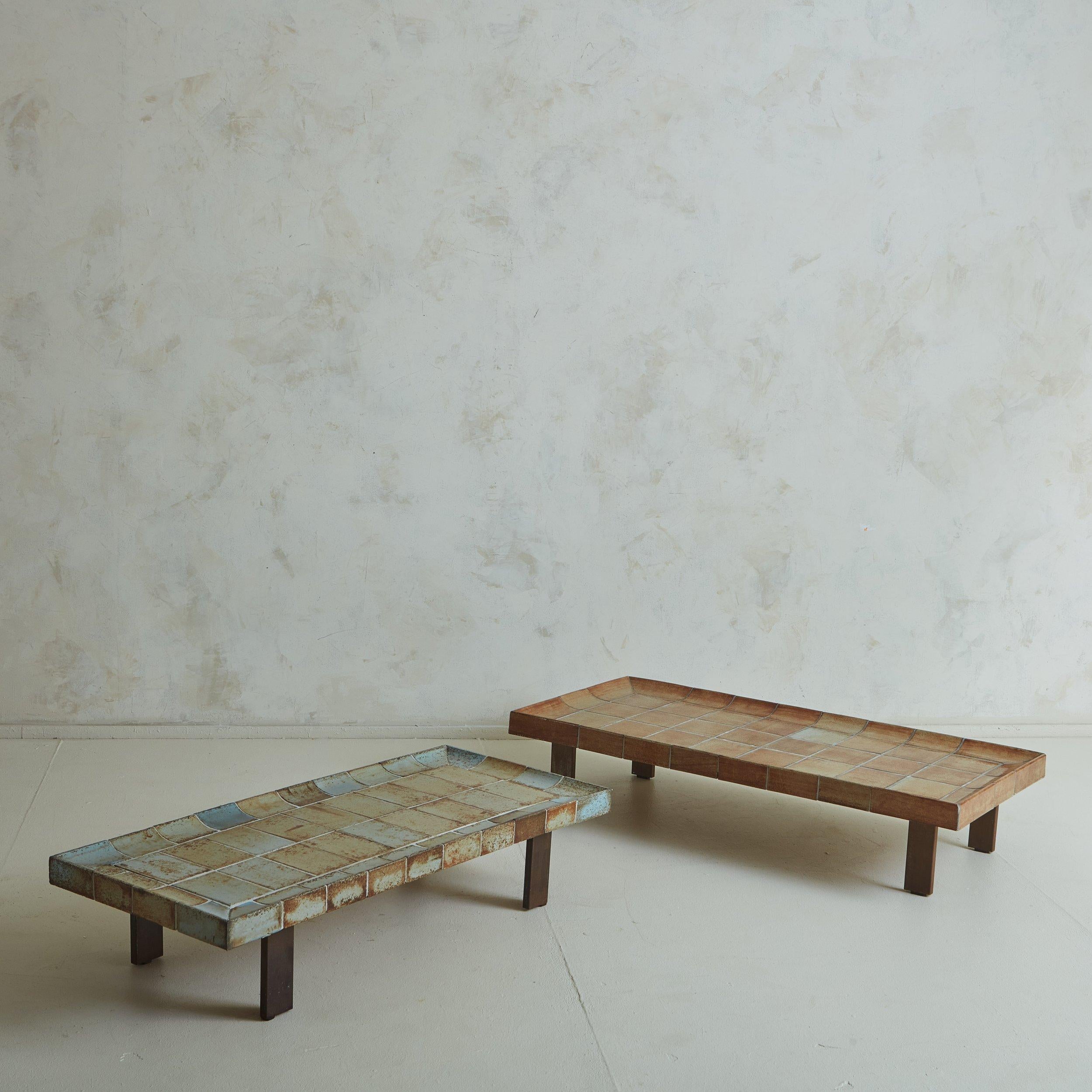 A 1960s ‘Cuvette’ coffee table by French ceramicist Roger Capron. This piece features a concave tabletop clad in gorgeous earthenware ceramic tiles from Vallauris, France. The tiles have rich color variations, which include a range of burnt orange