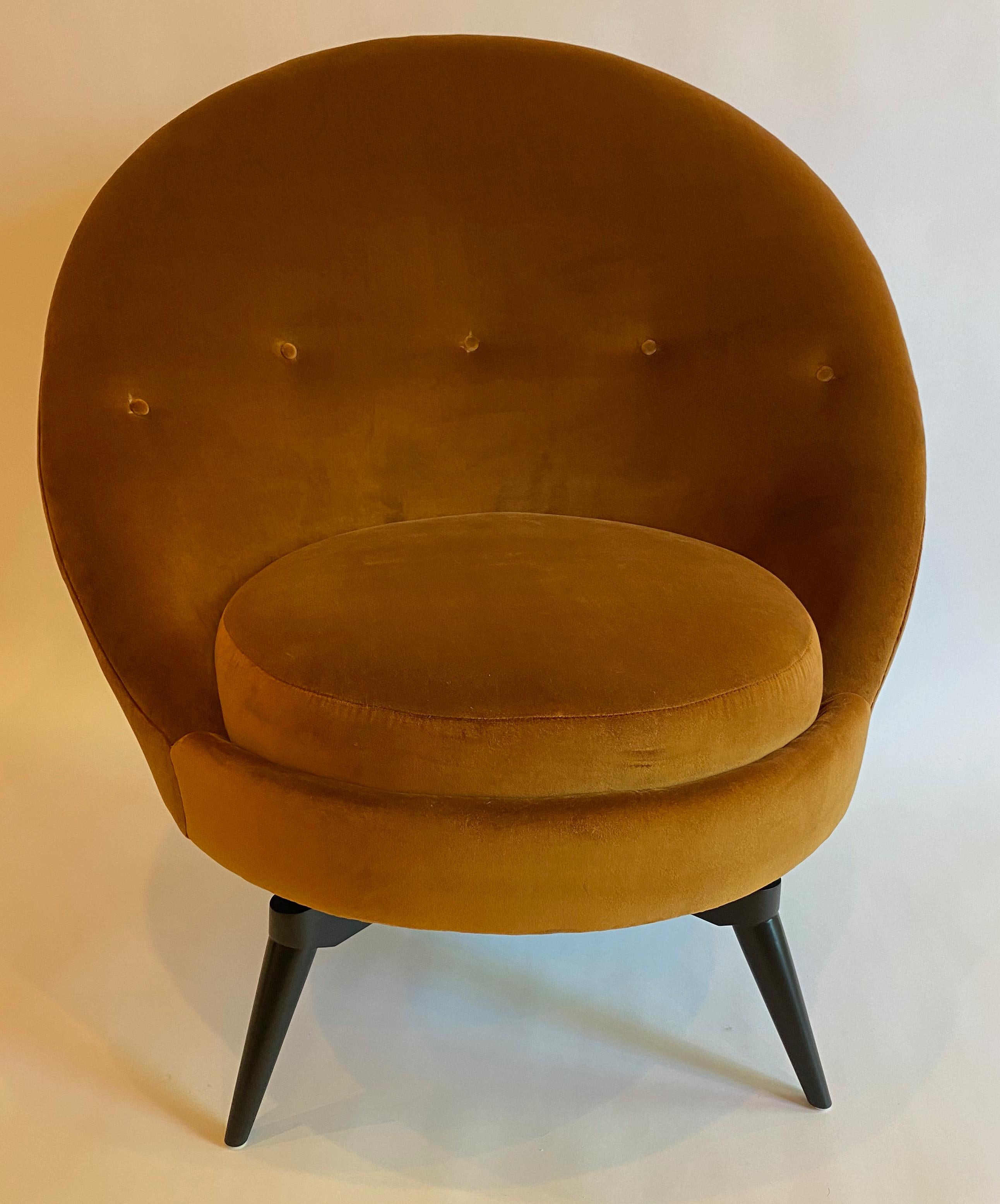 Swivel egg chair in the French midcentury style. This sophisticated chair is upholstered in heavy-weight burnt orange/gold velvet. This super stylish and versatile example is as comfortable as it looks and is painstakingly patterned with a hardwood