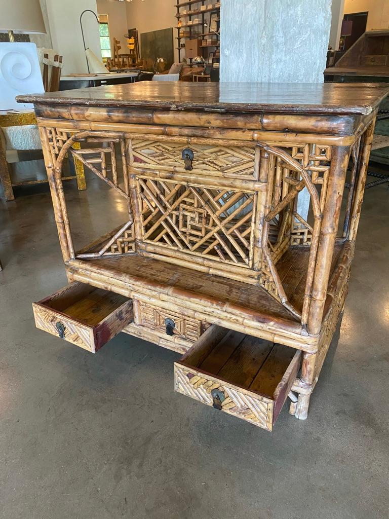 A burnt rattan bamboo and wood top table, having four drawers and open shelving. Makes lovely console, center table, dry bar or island. France, late 19th century.