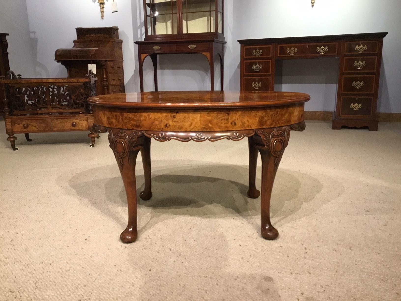A burr walnut 1920s period oval coffee table. Having an oval top veneered in beautifully figured burr walnut with a burr walnut frieze and supported on four elegant carved cabriole supports with pad feet. English, circa 1920.

Dimensions: 30