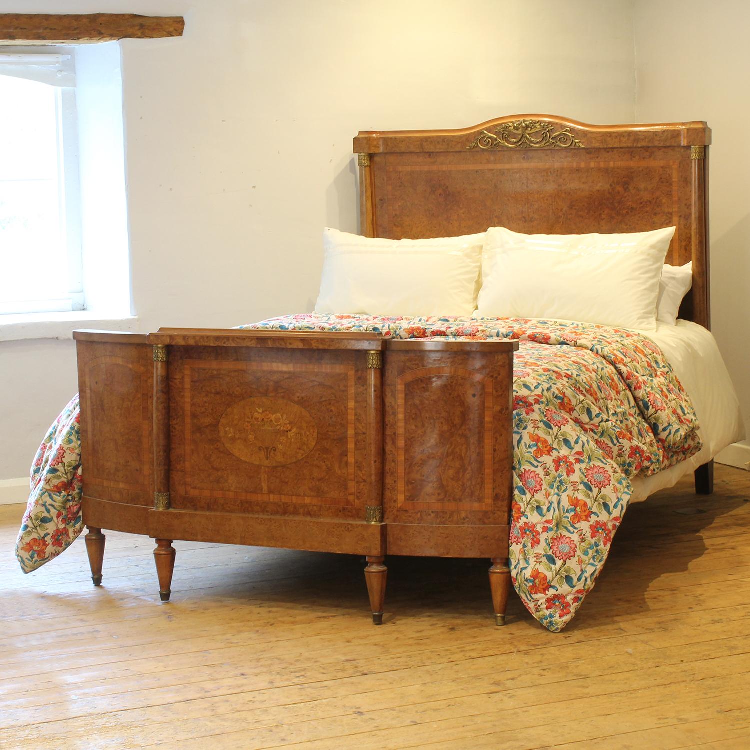 A superb example of an Art Deco antique bed with attractive burr walnut veneered frame, ormolu decoration, classical columned posts and delicate fruitwood inlay depicting an urn with flowers.

This bed accepts a US Queen Size (or UK King Size), 5ft