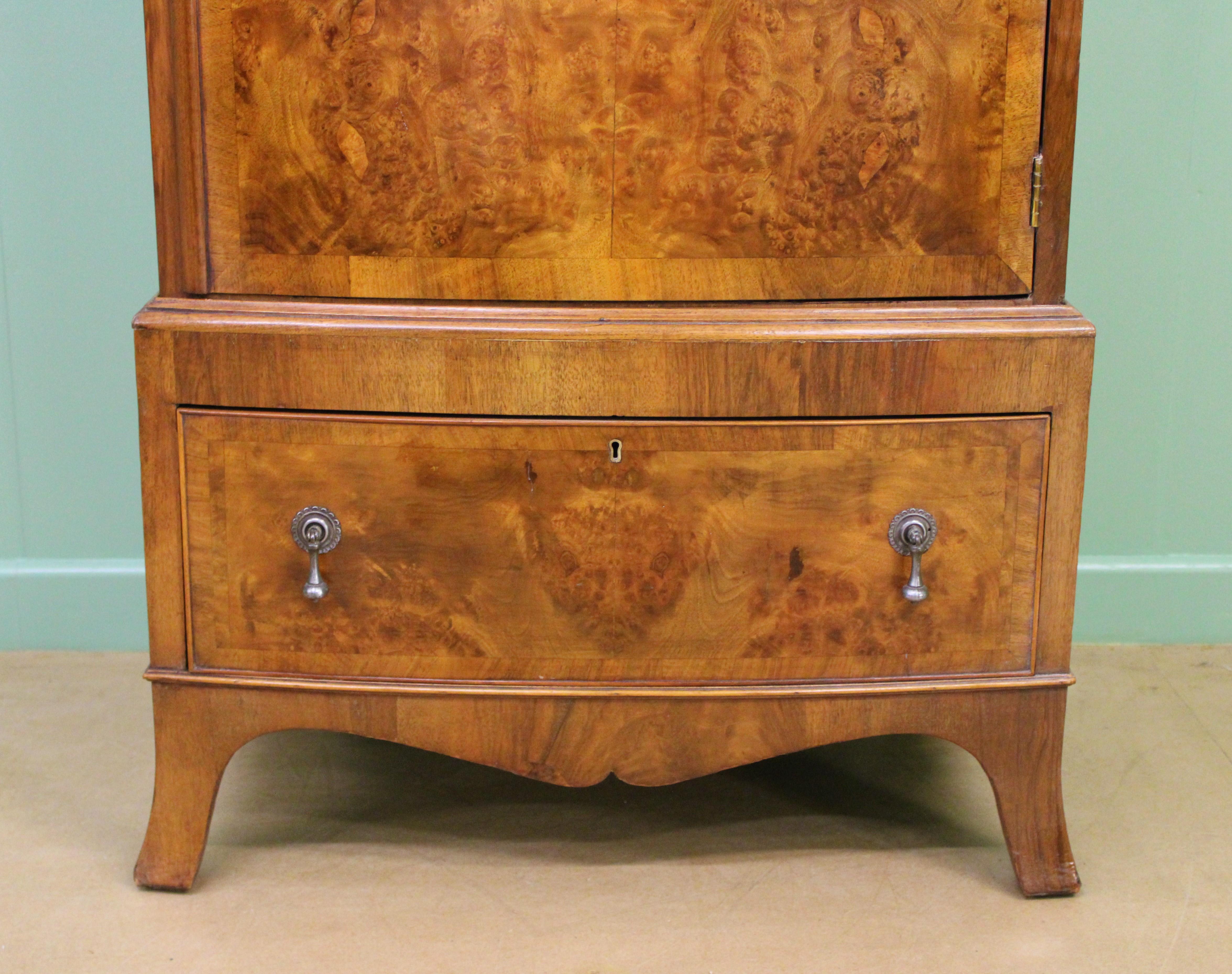 A good burr walnut bow fronted wardrobe of slender proportions. Well made in the queen Anne style in solid walnut with attractive burr walnut veneers. The single cupboard door (lockable, key supplied) opens to reveal storage space with a hanging